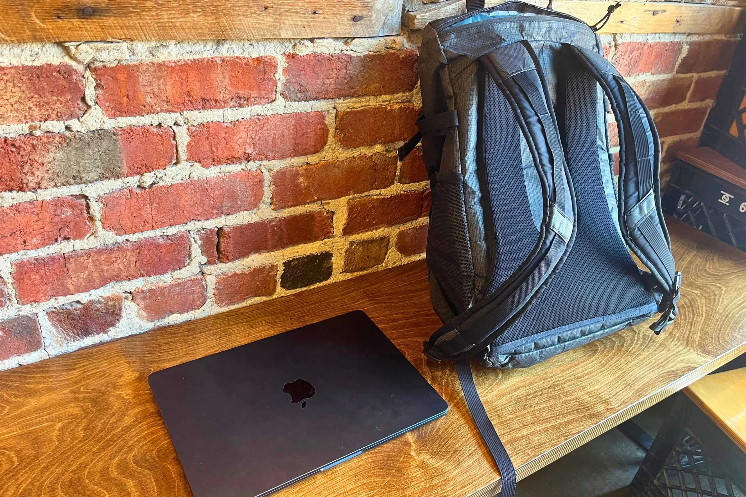 ULA Ultra Dragonfly 30L Adventure Travel Backpack beside a laptop on a table.