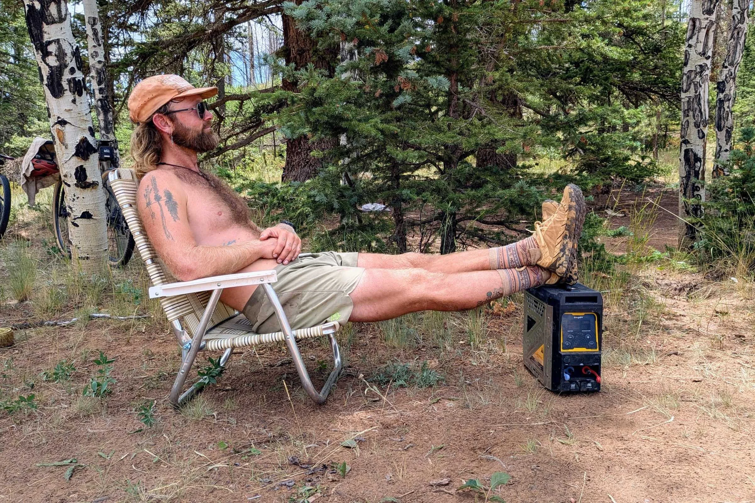 A man relaxing in a lawn chair in the comfortable rabbit FKT shorts
