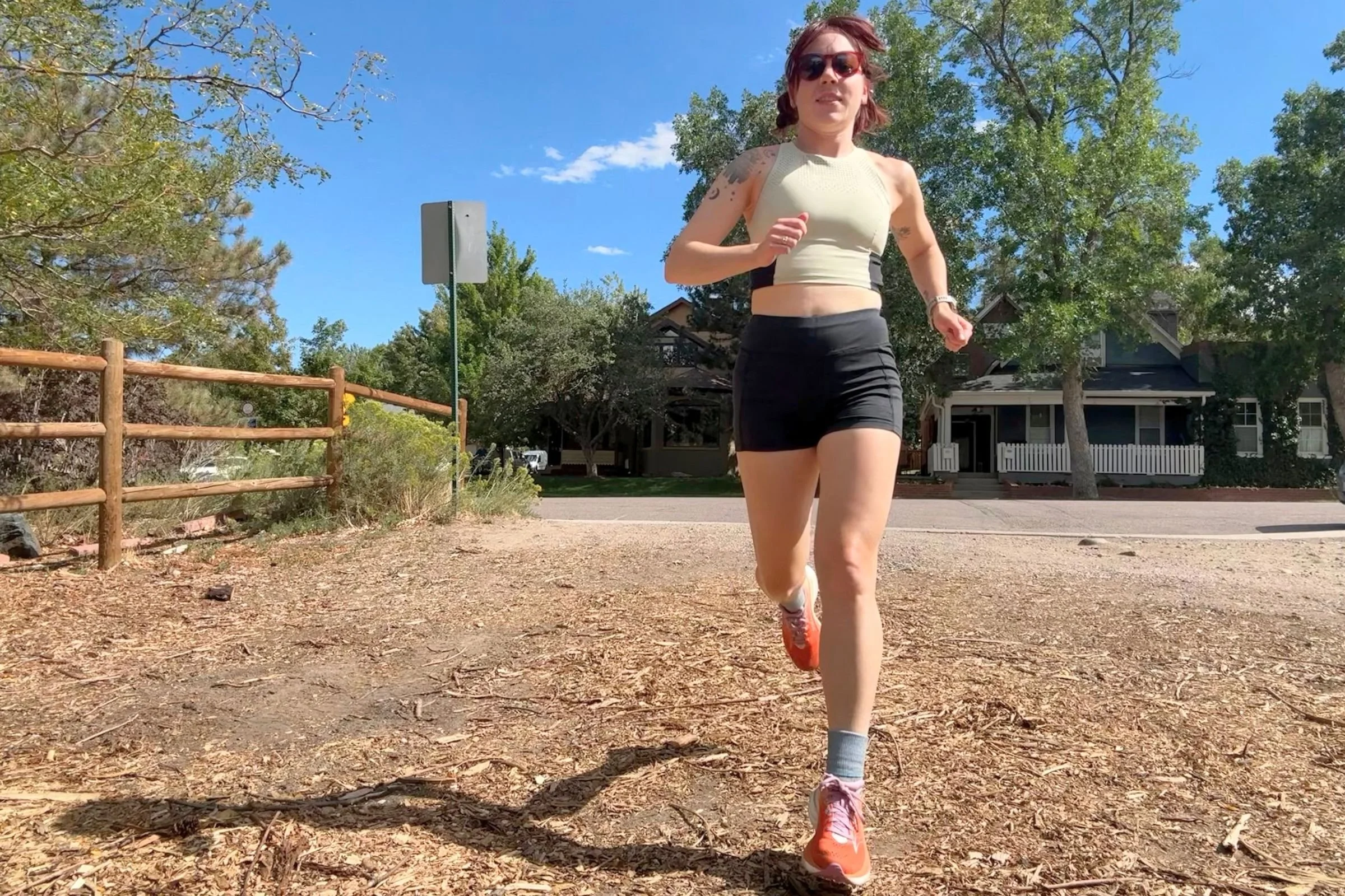 The author Becca Downs wearing the Saucony Ride 19s on a dirt path in a neighborhood.