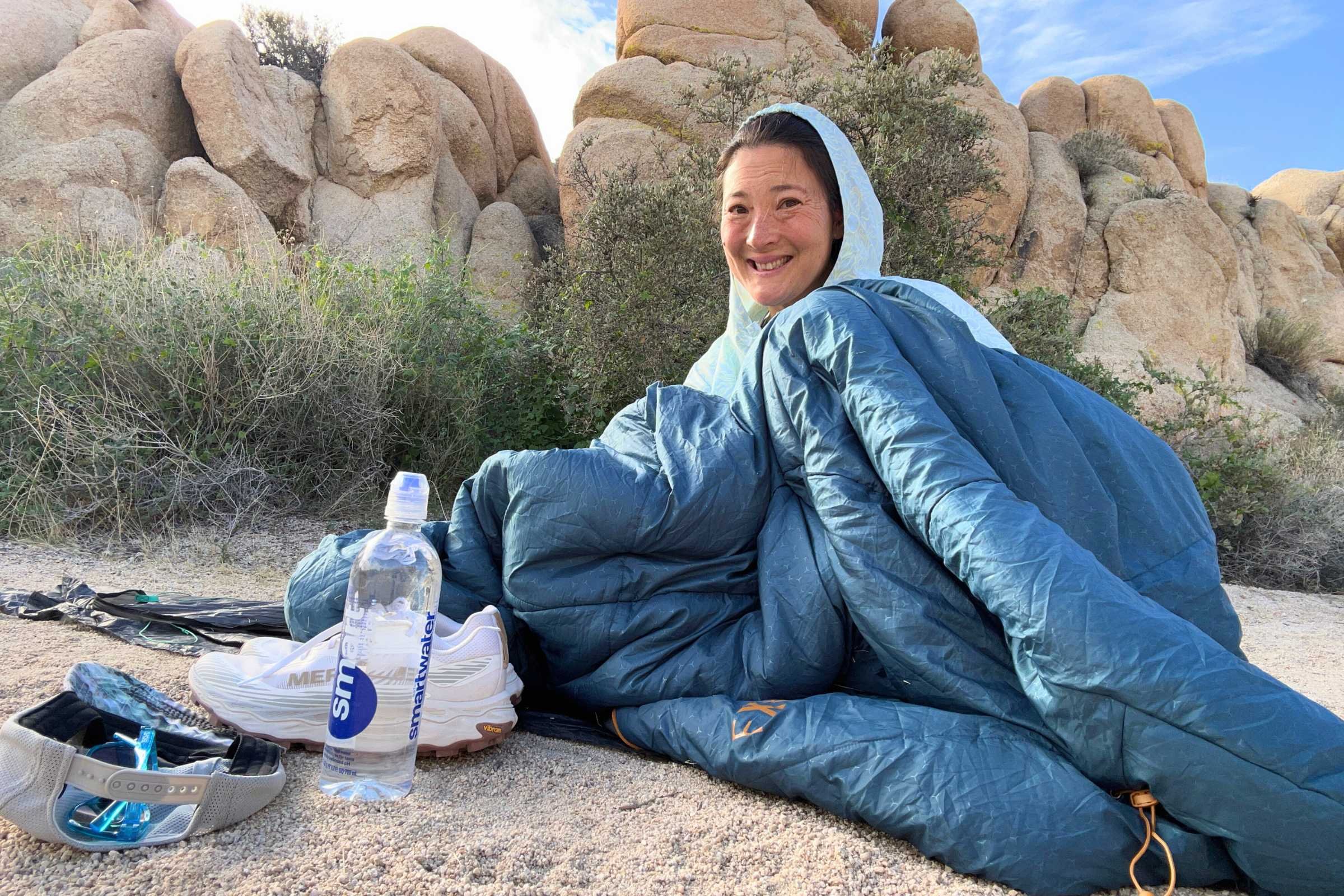 the author sitting in a blue exped deepsleep sleeping bag outside on a camping trip