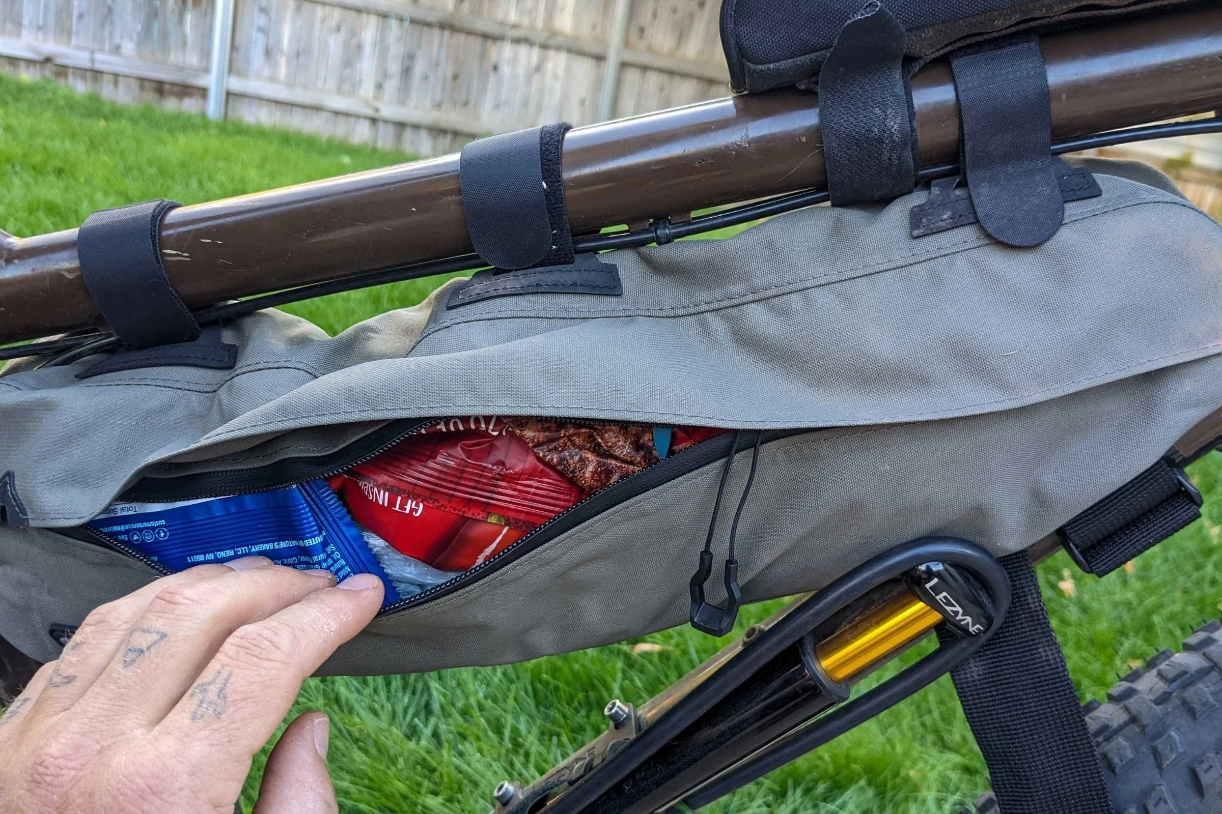 Close-up of the Topeak Midloader bike frame bag loaded with snacks. Since it is made of thin material, it works best when fully packed.