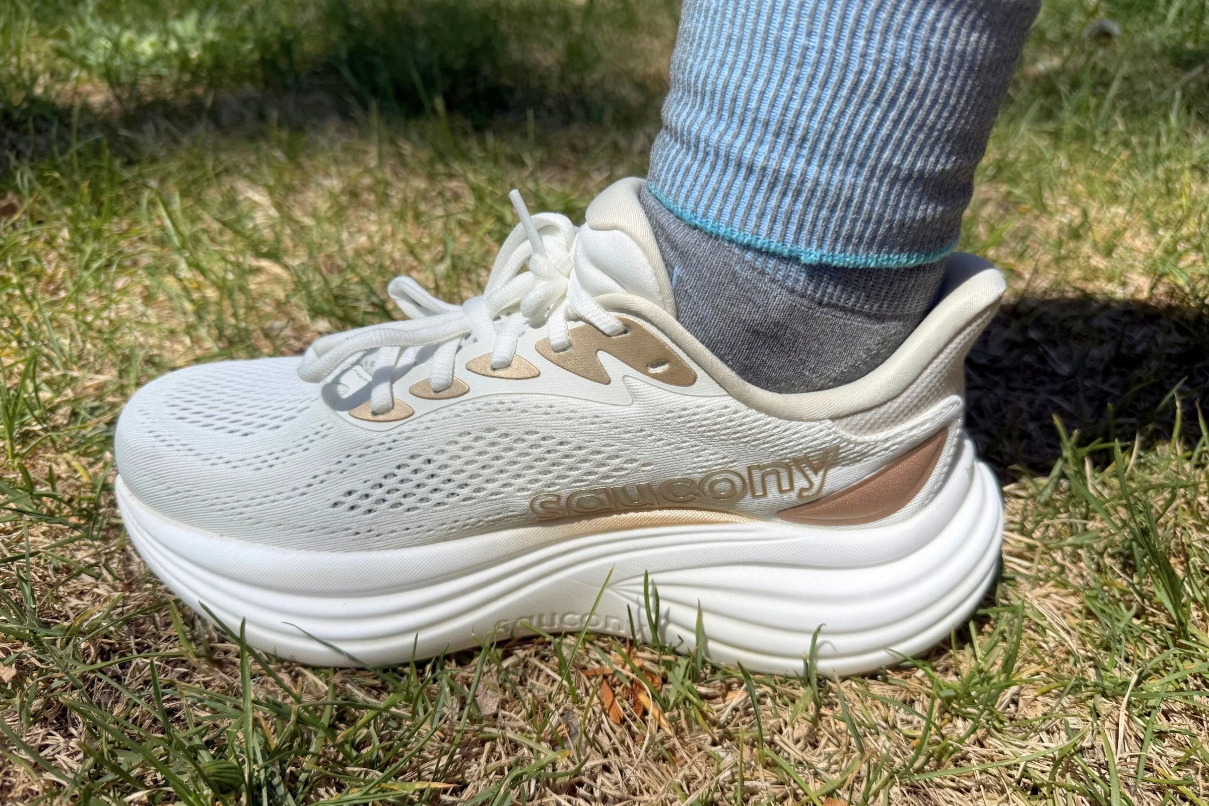 Close-up of a runner wearing Saucony Triumph 24 road running shoes on grass