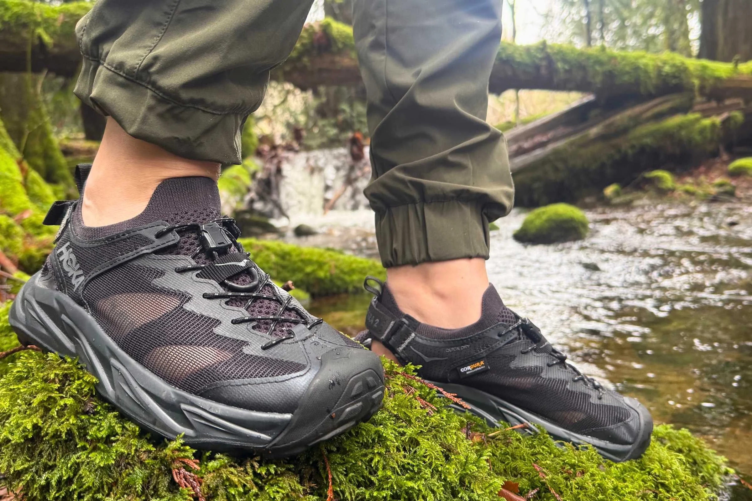 someone wearing the hoka hopara 2 water shoes on a mossy rock by a creek