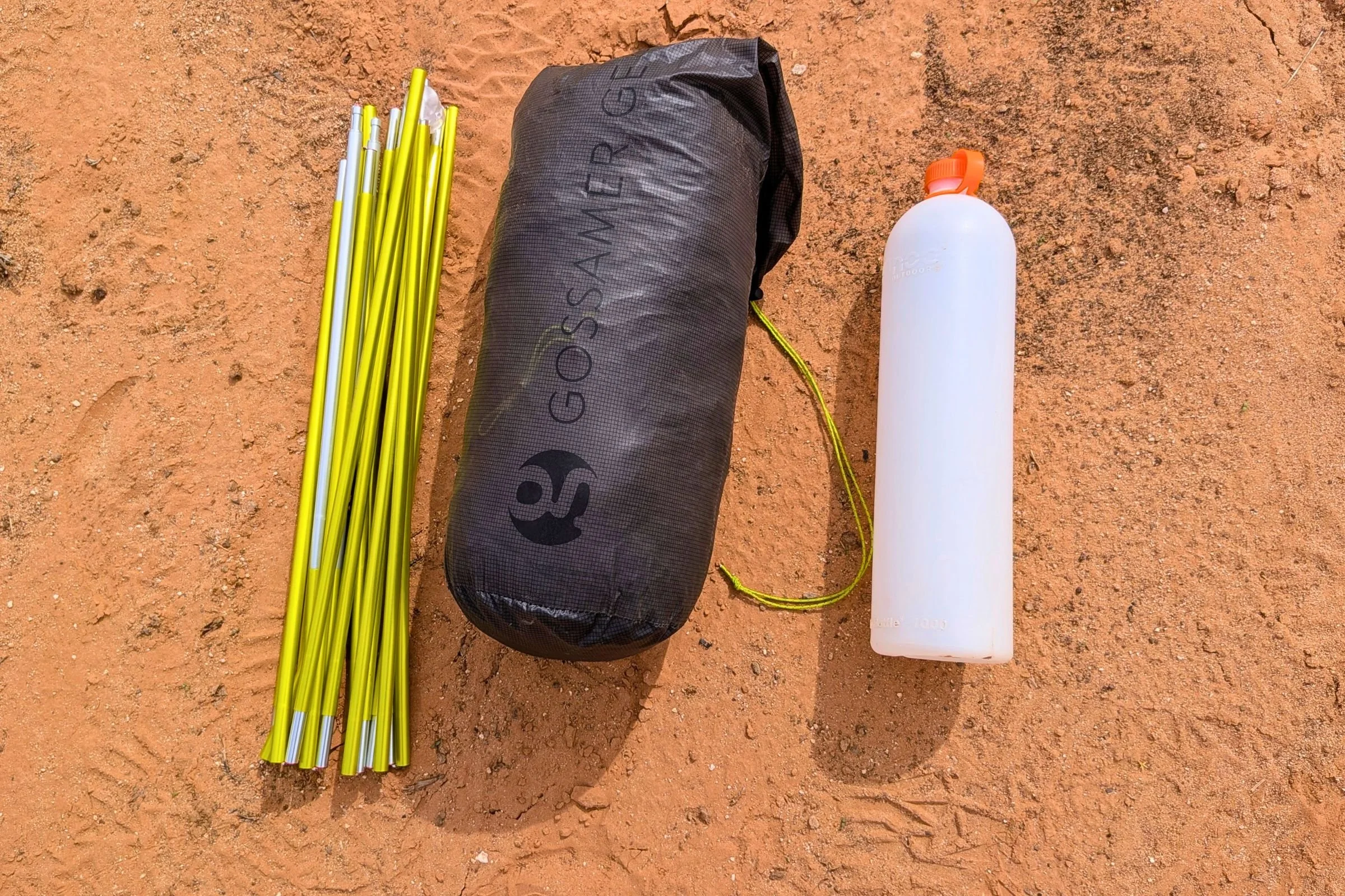Packed Gossamer Gear The Free and folded tent poles beside a 1-liter water bottle for scale.