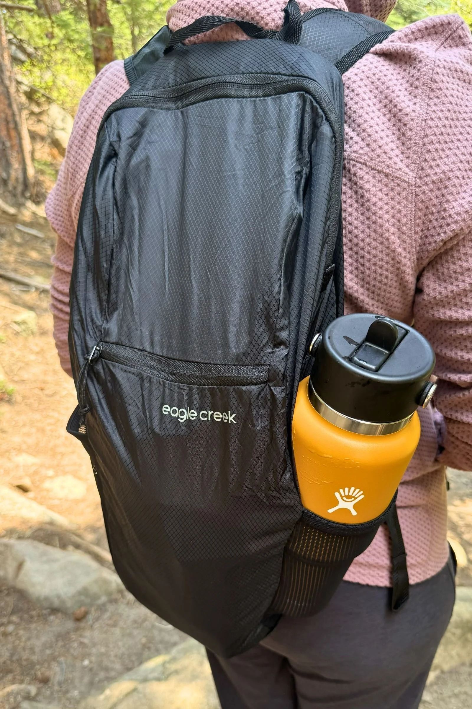 Person carrying a Hydro Flask 32 oz Travel Bottle with a backpack during daily use.