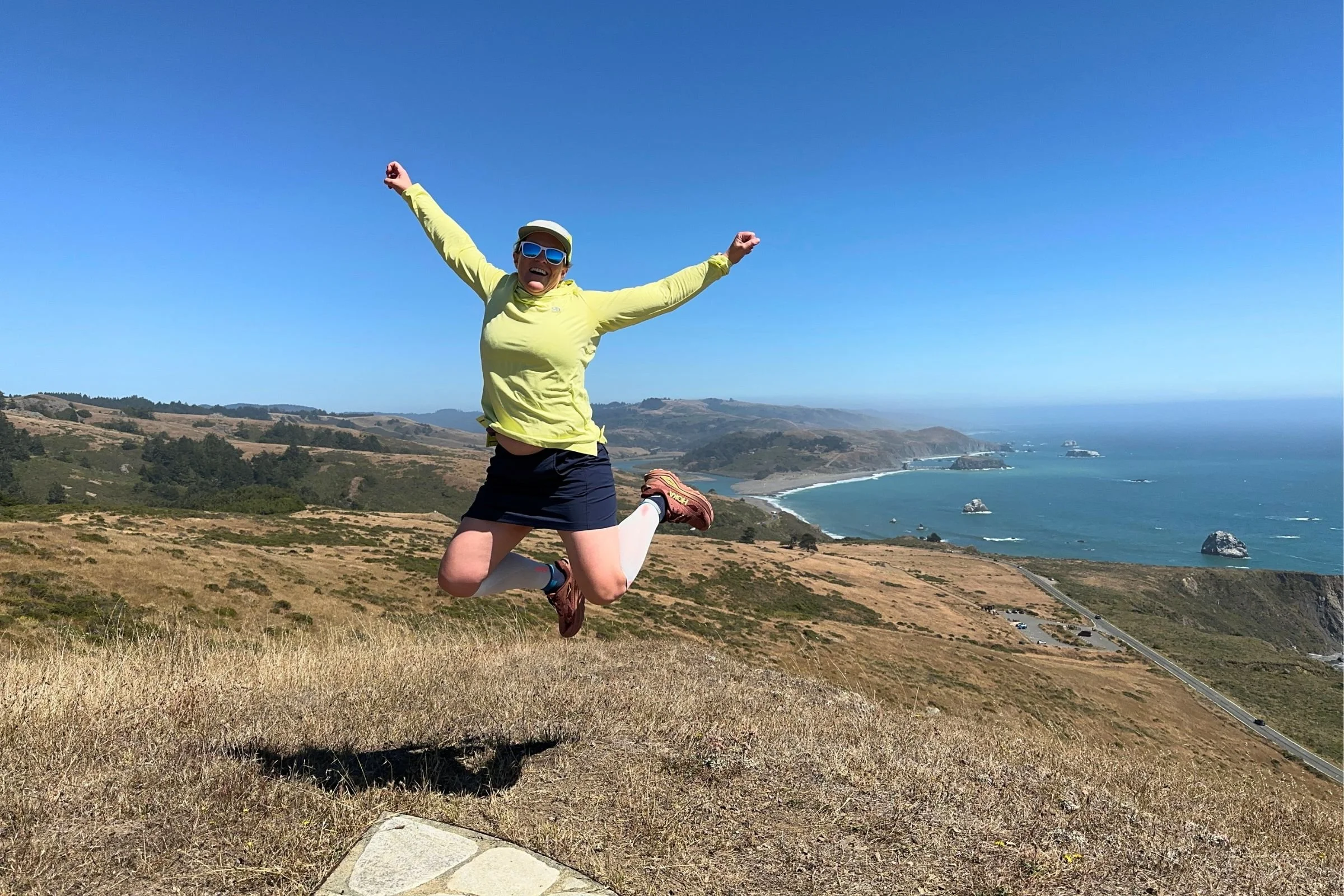 jump above a coastline and fields while testing calf compression sleeves