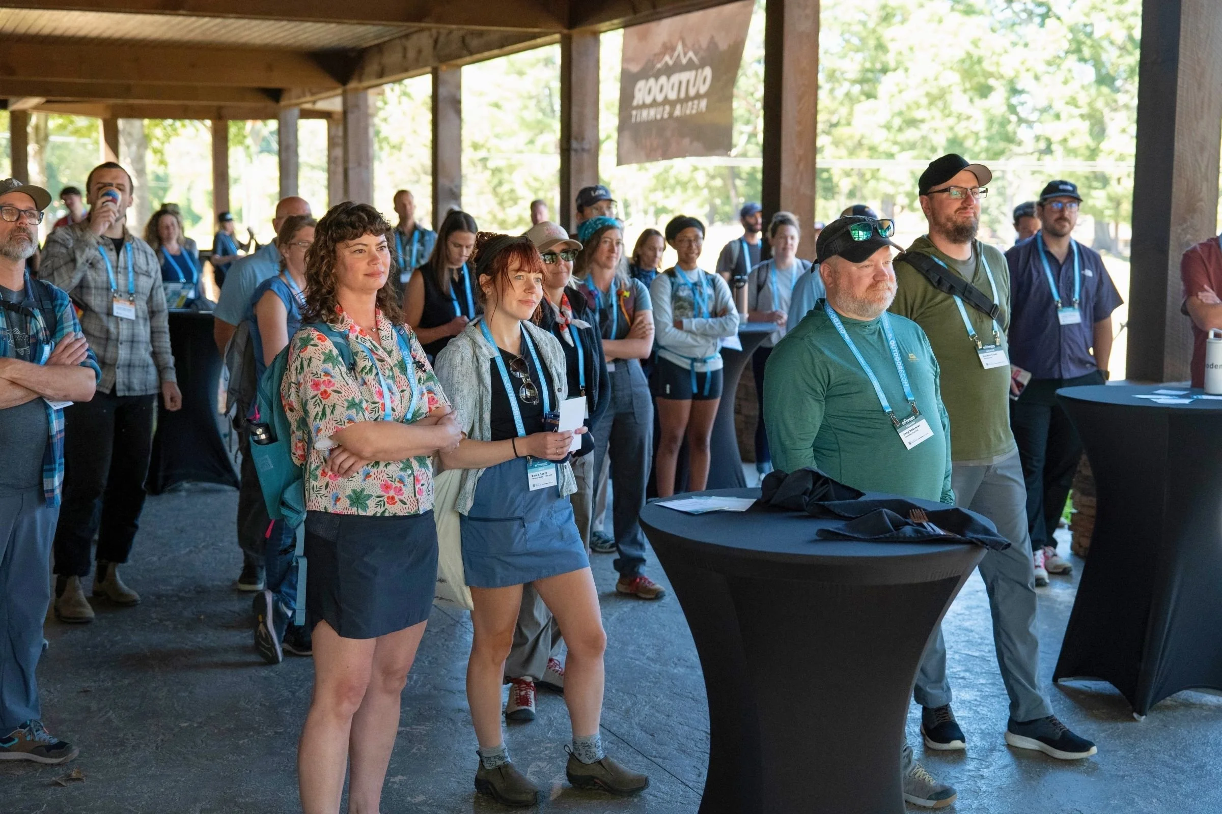 A group of people stands beneath a covered outdoor area at the 2026 Outdoor Media Summit.