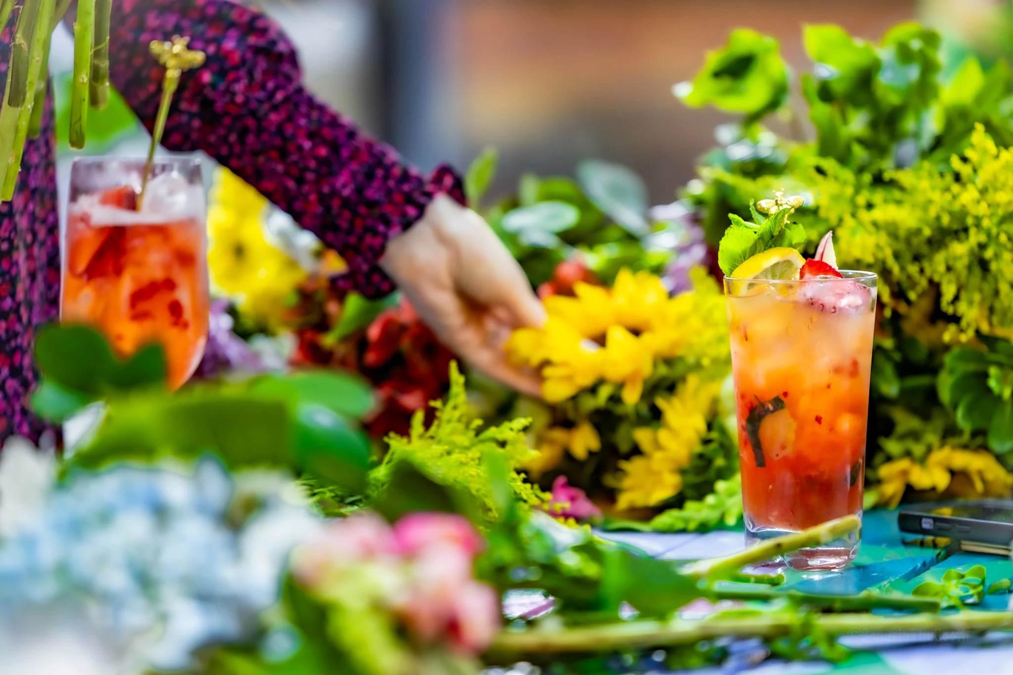 Refreshing fruity botanical beverages on a table covered in flowers at a private garden party at Neon Workspace