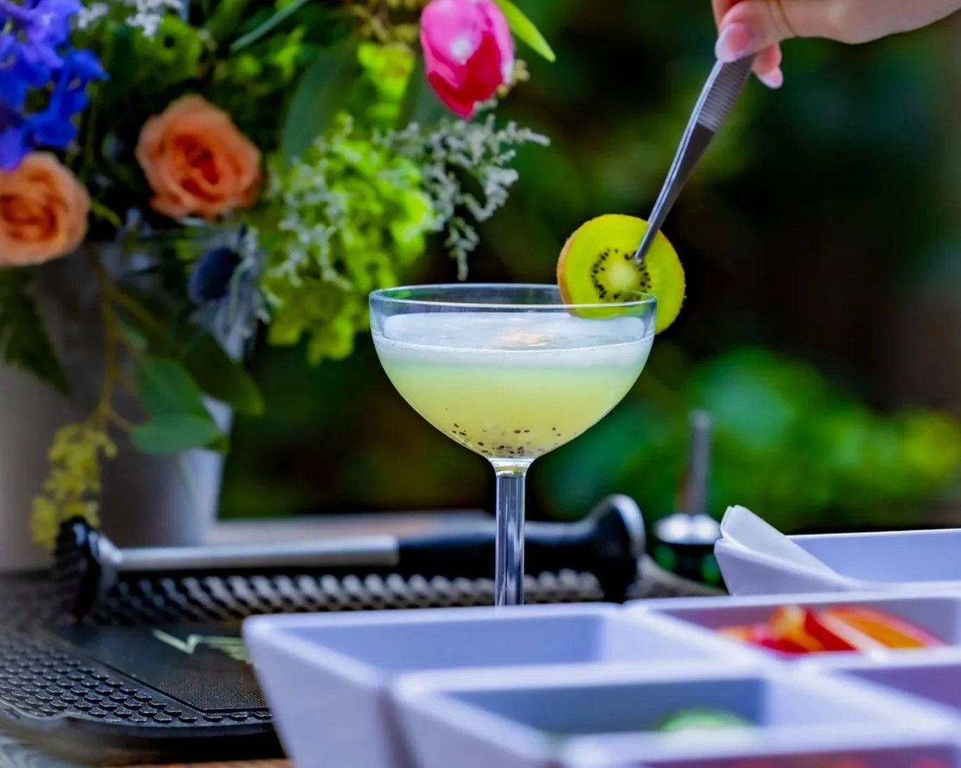 Traveling bartender makes beautiful kiwi green cocktail for outdoor event