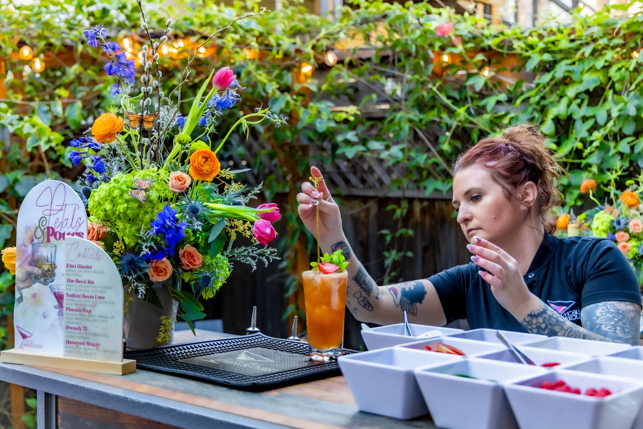 Event bartender artfully placing a stir stick into a Collins glass at an outdoor event