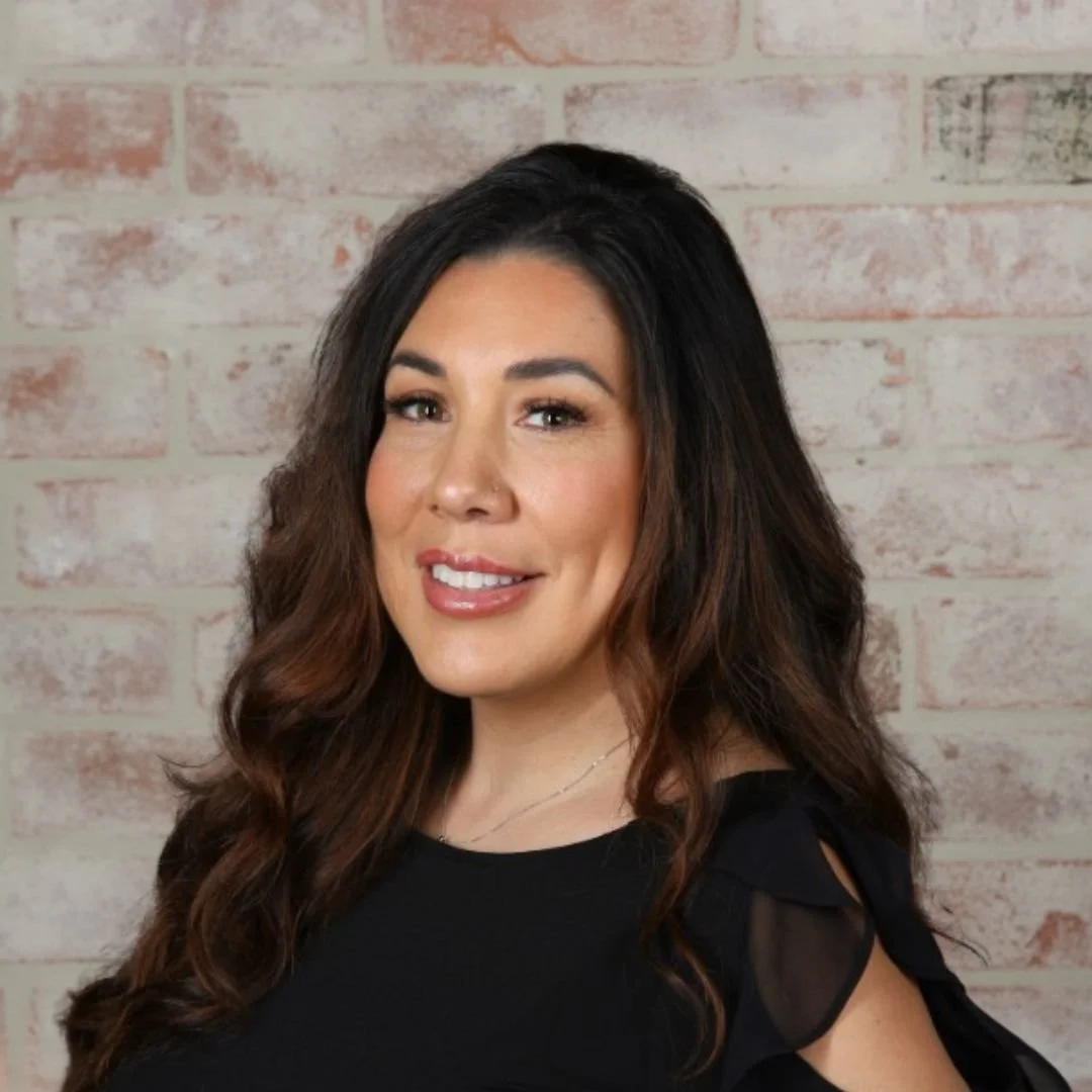 Mobile Mixologist Human Resource Manager Lareina Garcia in front of a white brick wall 