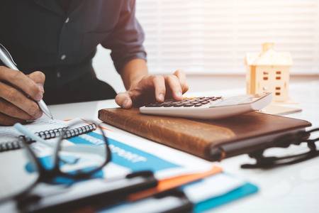 93009739-business-man-accountant-using-calculator-to-calculating-bugget-money-tax-loan-.jpg