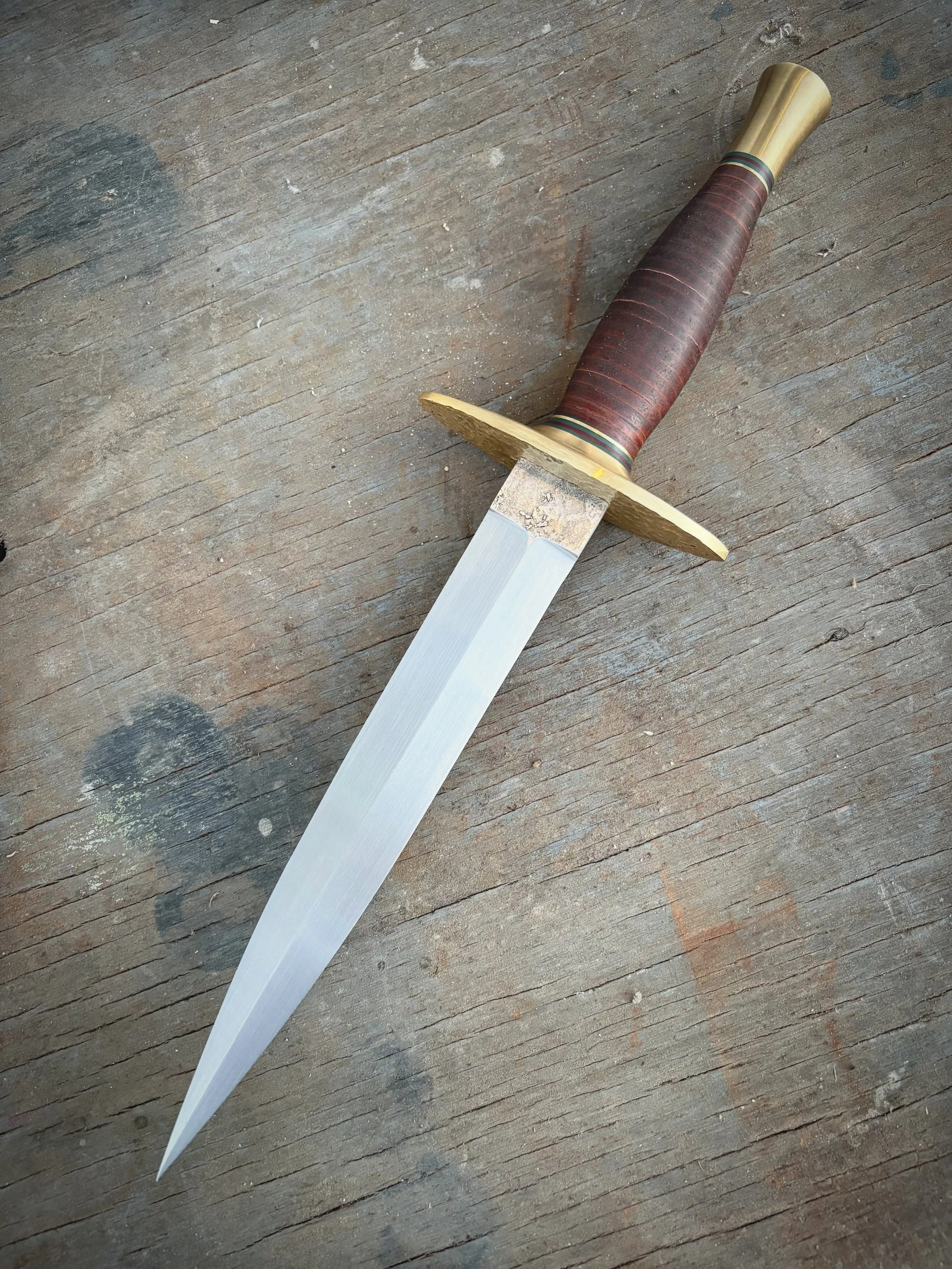 Stacked leather dagger with hand, threaded Pommel and hammered guard. Very fun proof of concept, would you like to see more of this style?