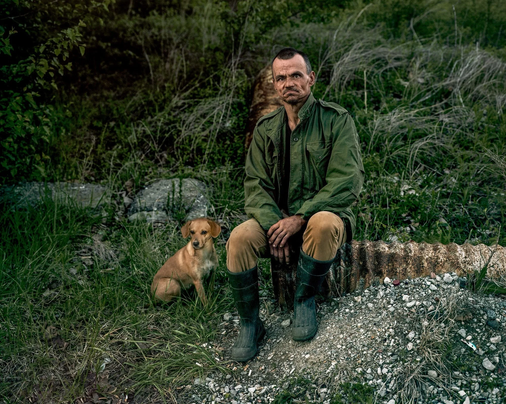 DANNY AND HIS DOG, Woodbine, Kentucky 

As I drove north through Eastern Kentucky&rsquo;s winding valleys, the sky began to darken into a twilight blue and I continued to scan the many roads winding off into the isolated hollers for something to phot