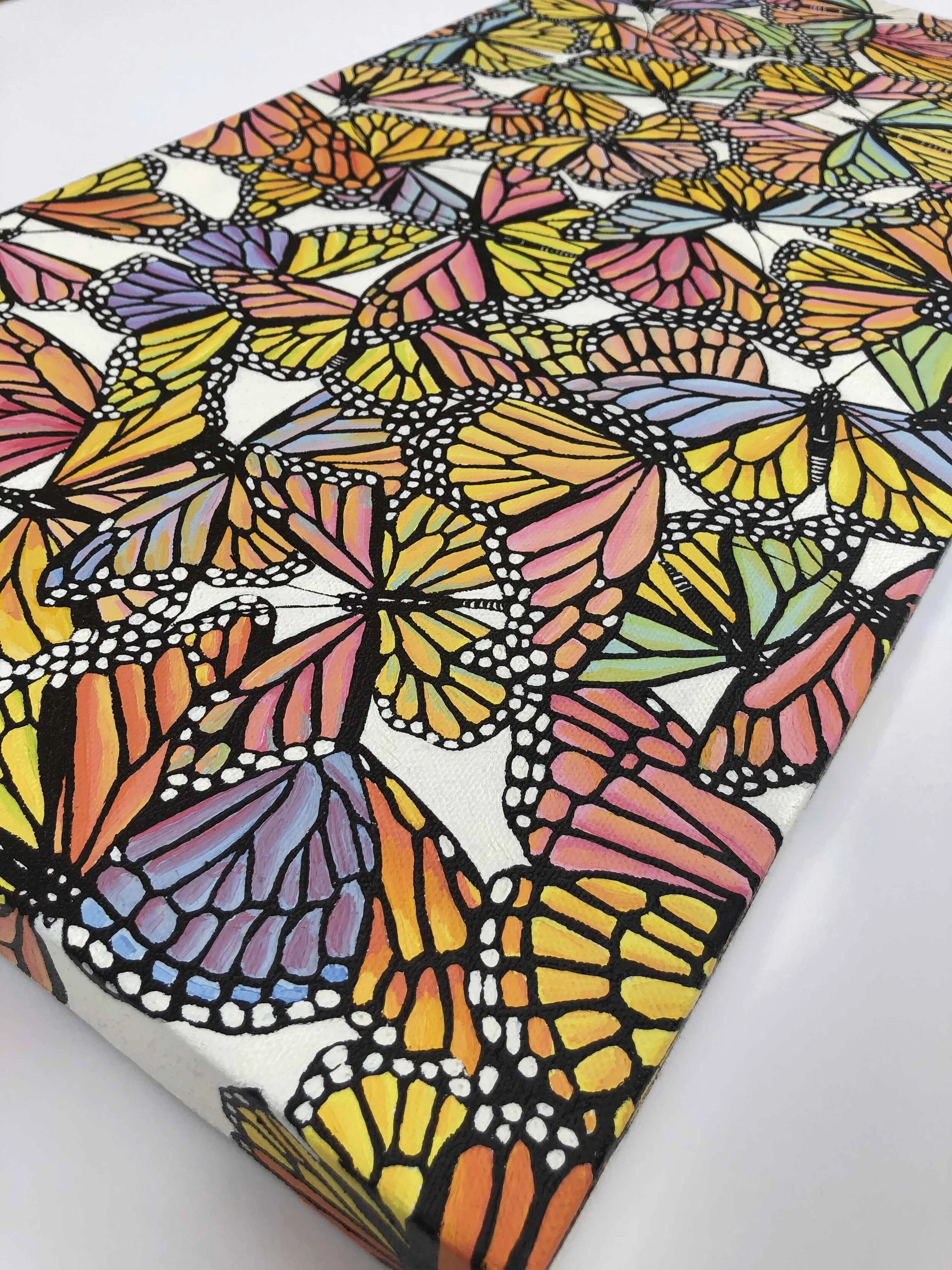 Photo of the oil painting titled "Pastel Monarch Scatter," by Kristin Frank. It features pastel colored monarch butterflies in flight during their migration.