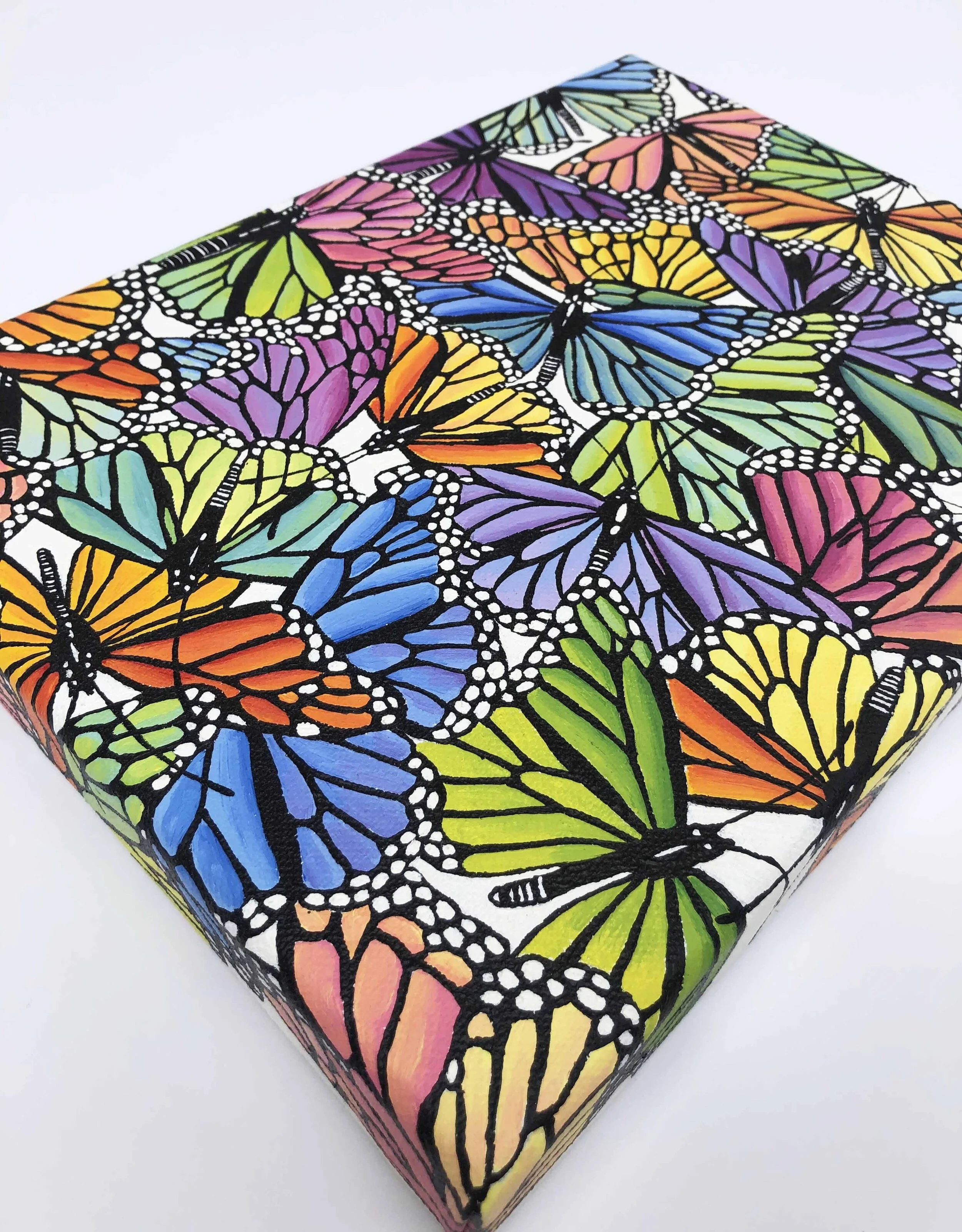 Photo of the original oil painting on canvas titled "Rainbow Scatter."  It features colorful monarch butterflies in flight during their migration.