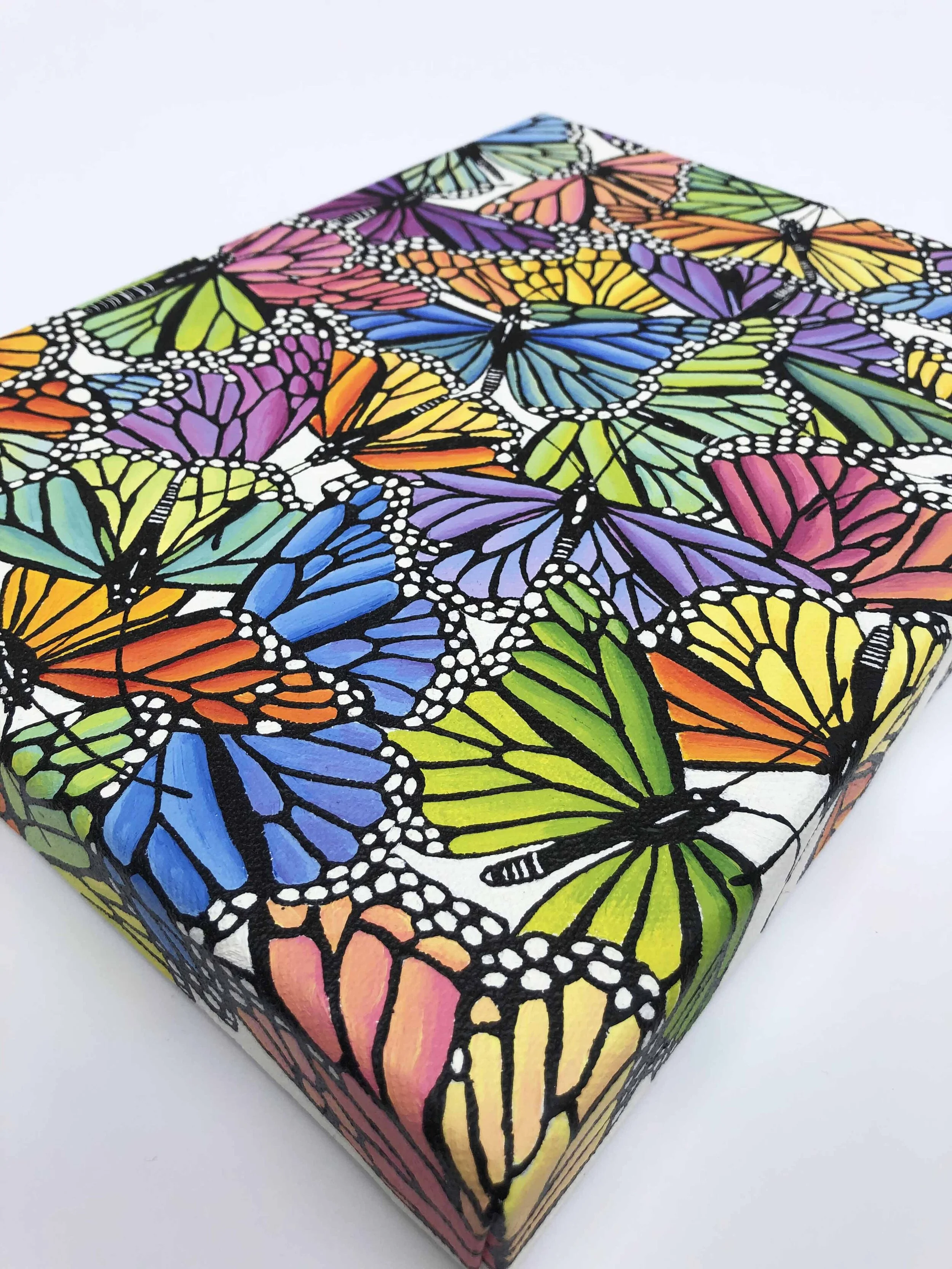 Photo of the original oil painting on canvas titled "Rainbow Scatter."  It features colorful monarch butterflies in flight during their migration.
