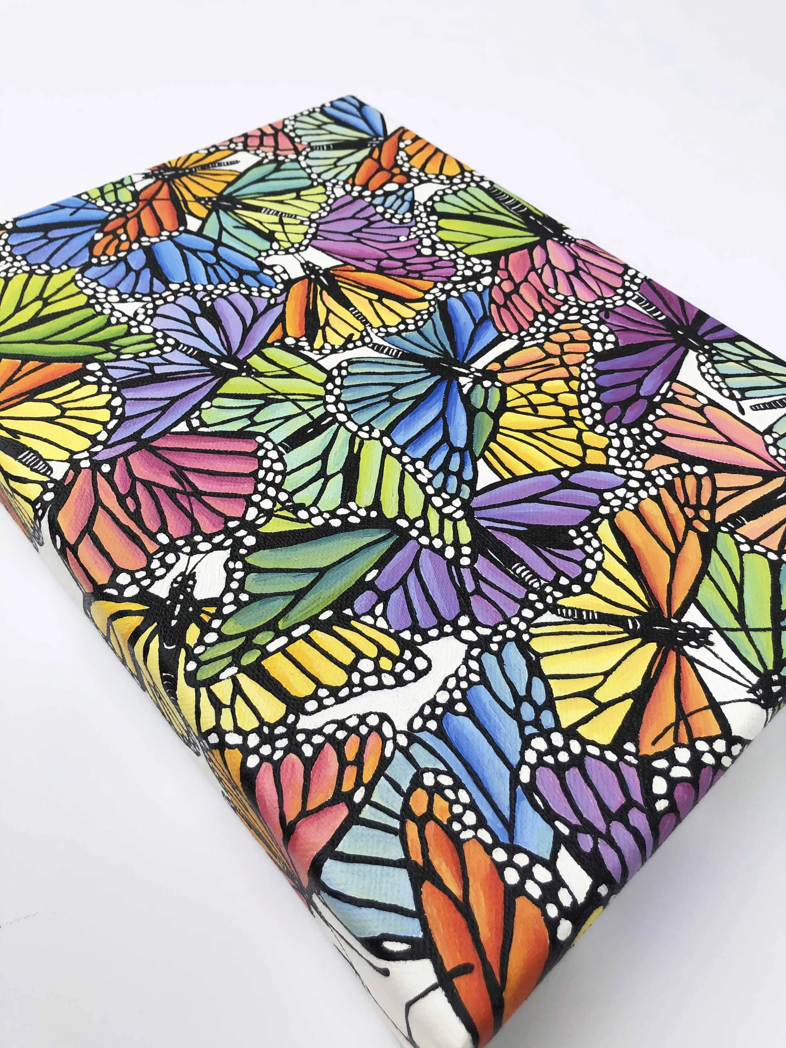 Photo of the original oil painting on canvas titled "Rainbow Scatter."  It features colorful monarch butterflies in flight during their migration.