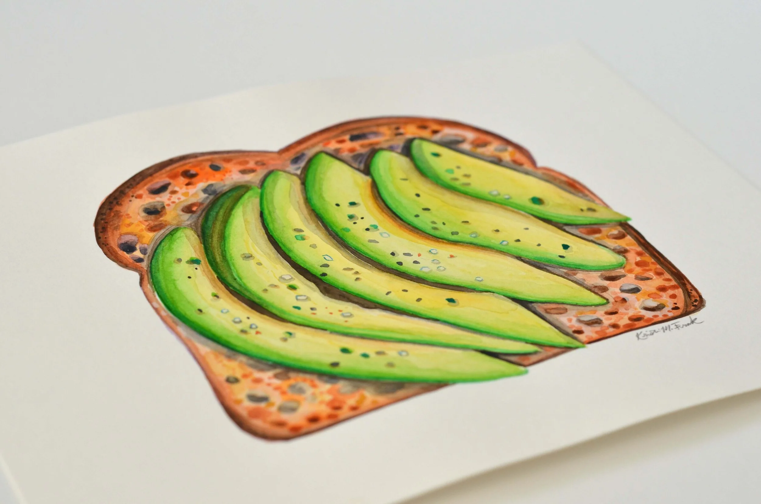 Watercolor of sliced avocado on toast. This painting is titled "Avocado Toast No.1" and it is by Kristin Frank.