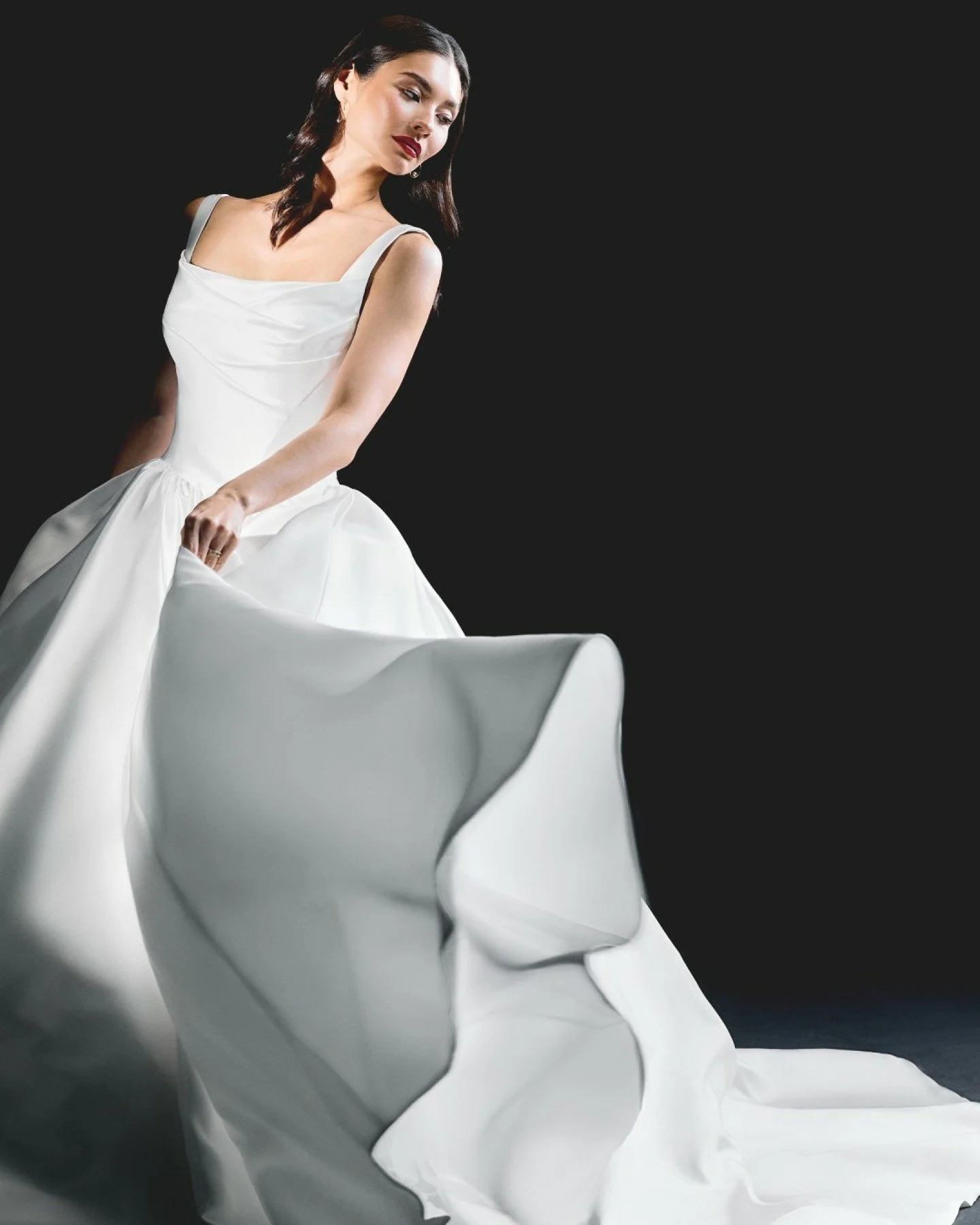 New arrival: The Maris gown by Justin Alexander Signature has arrived, a structured Mikado ball gown with a square neckline, slim straps, corset tie back, and a basque waist flowing into a full skirt with pockets.
Modern pleating and seaming sculpt t