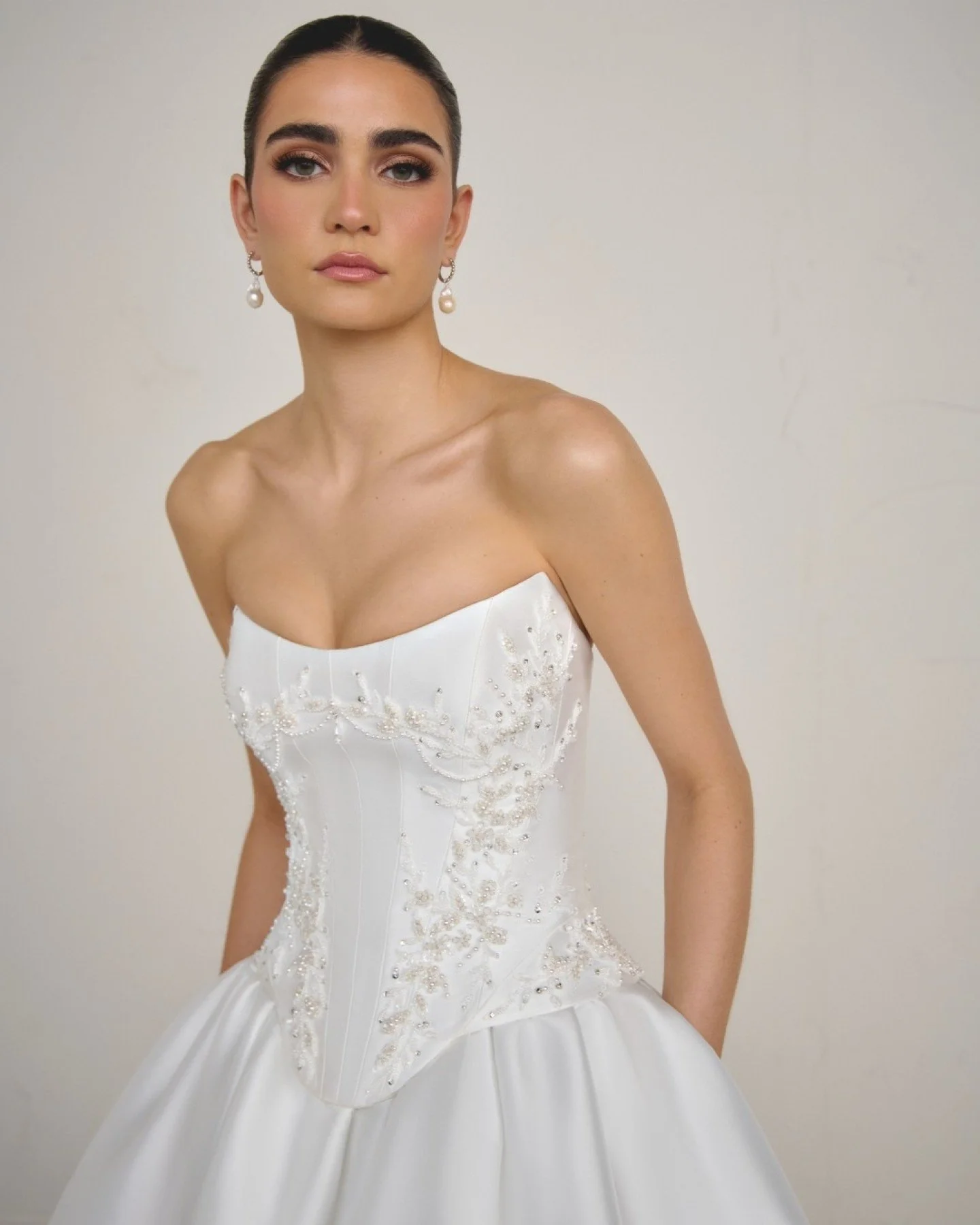 New to & Wolf Bridal is Solara by Justin Alexander Signature. A show-stopping ball gown in clean Mikado. The corset-style bodice sparkles with pearls, crystals, sequins and beads, flowing into a gathered skirt with a dramatic cathedral train. Wit