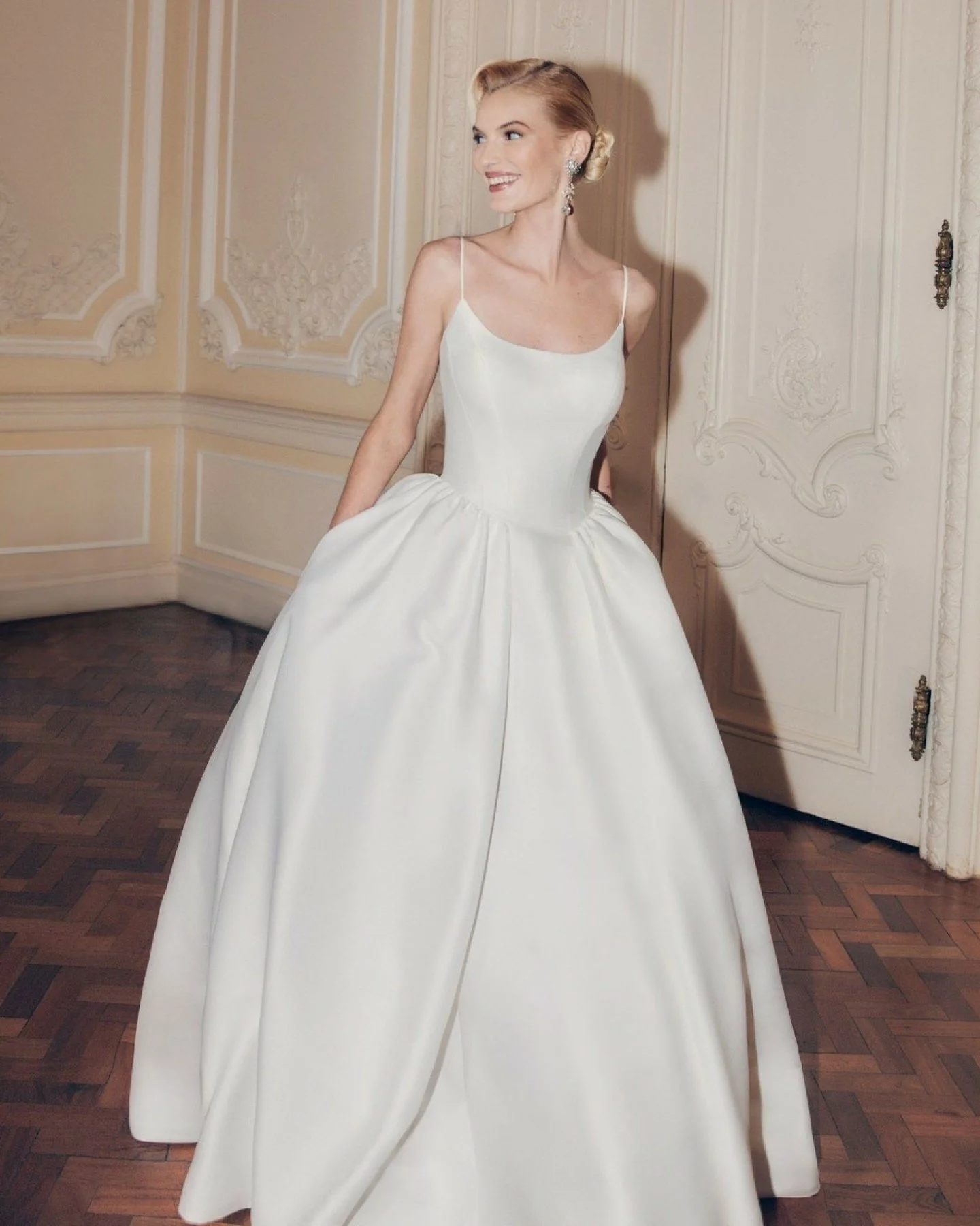 Meet Daphne by Ellis Bridals. A dramatic dropped-waist ballgown in textured Mikado, designed for brides who love impact and versatility. With a scoop neckline, delicate spaghetti straps and soft gathers at the hip, this gown flows into a full skirt t