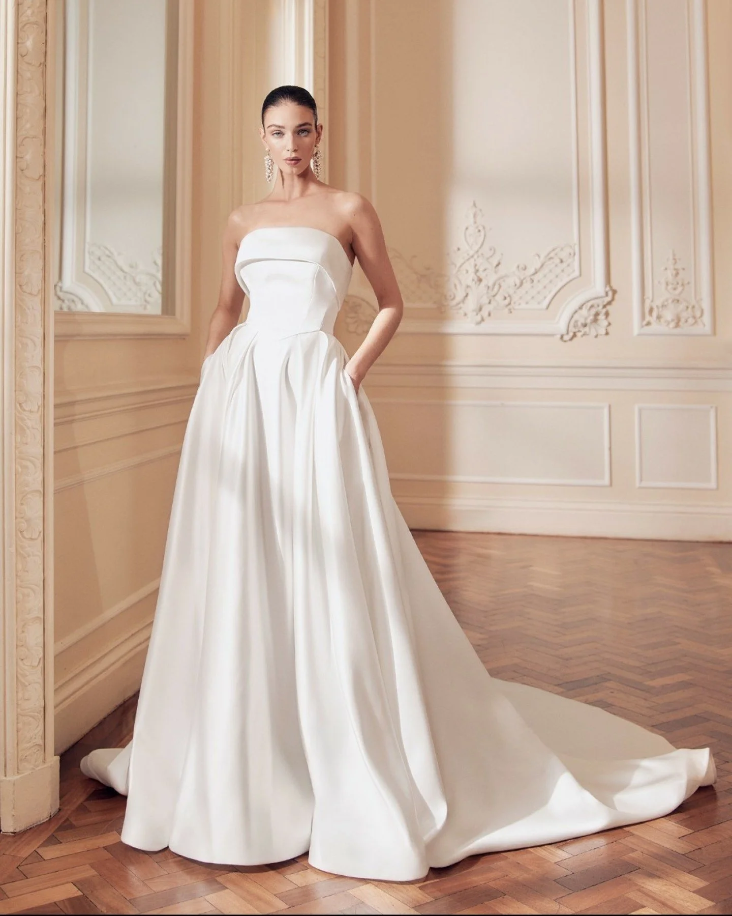 Annabelle by Ellis Bridals is a beautifully structured strapless ballgown designed for brides who love classic silhouettes without the fuss. The folded straight bodice feels clean and contemporary, while soft pleats fall into a full skirt that moves 