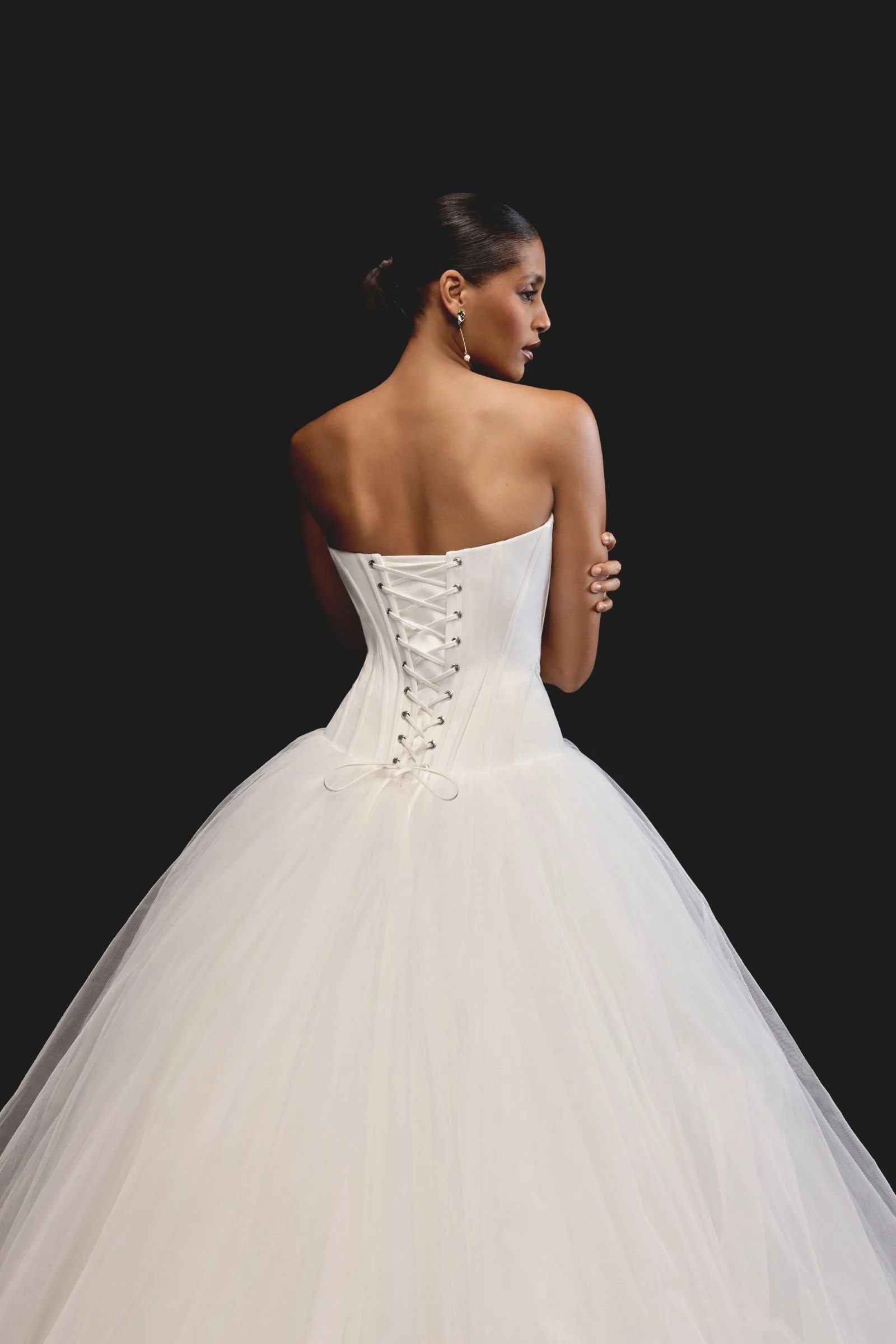 Justin Alexander Signature Rhiannon satin and tulle ballgown with cat-eye neckline, exposed boning, corset bodice, dropped Basque waist and chapel-length train at & Wolf Bridal