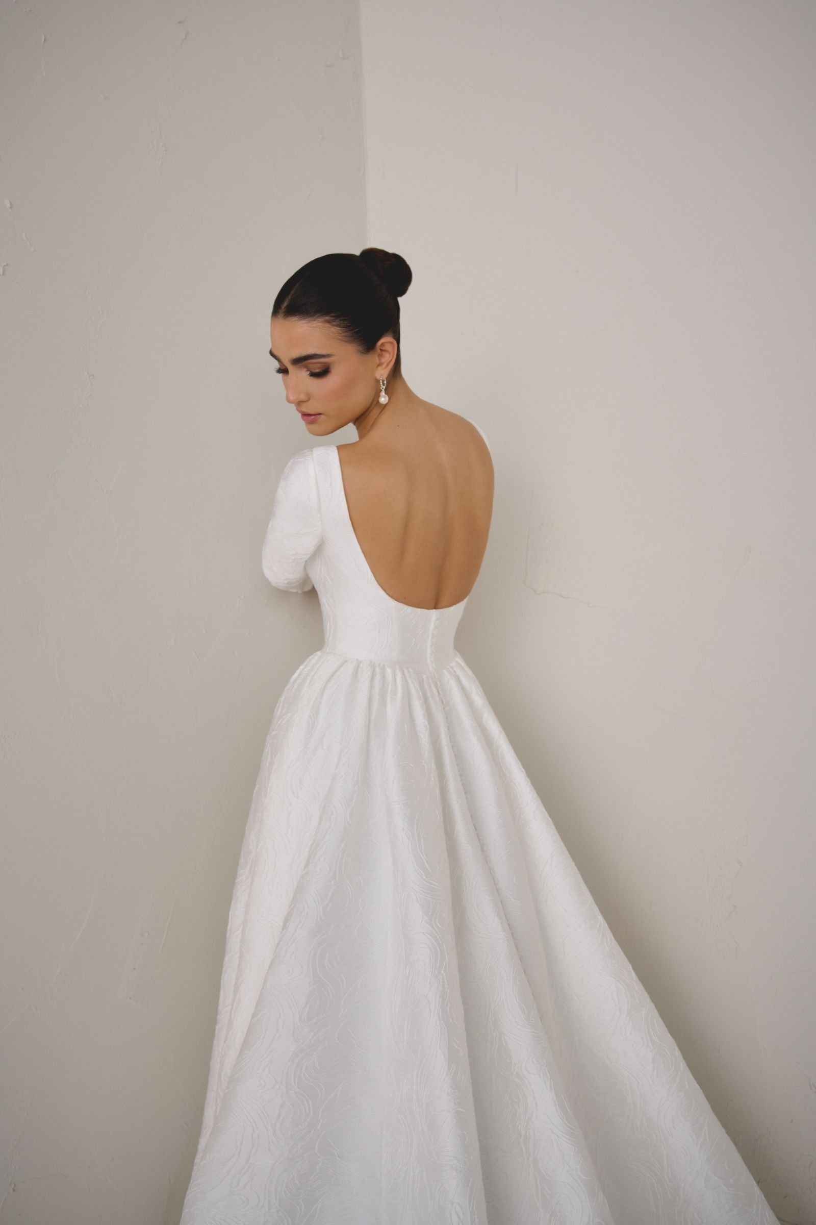 Justin Alexander Signature Calista brocade A-line wedding dress with Sabrina neckline, long sleeves, princess seams, pockets and square back with chapel-length train.