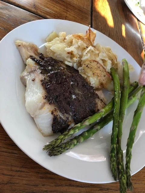 Roasted fish with sun-dried tomato and black olive tapenade, potato gratin and grilled asparagus