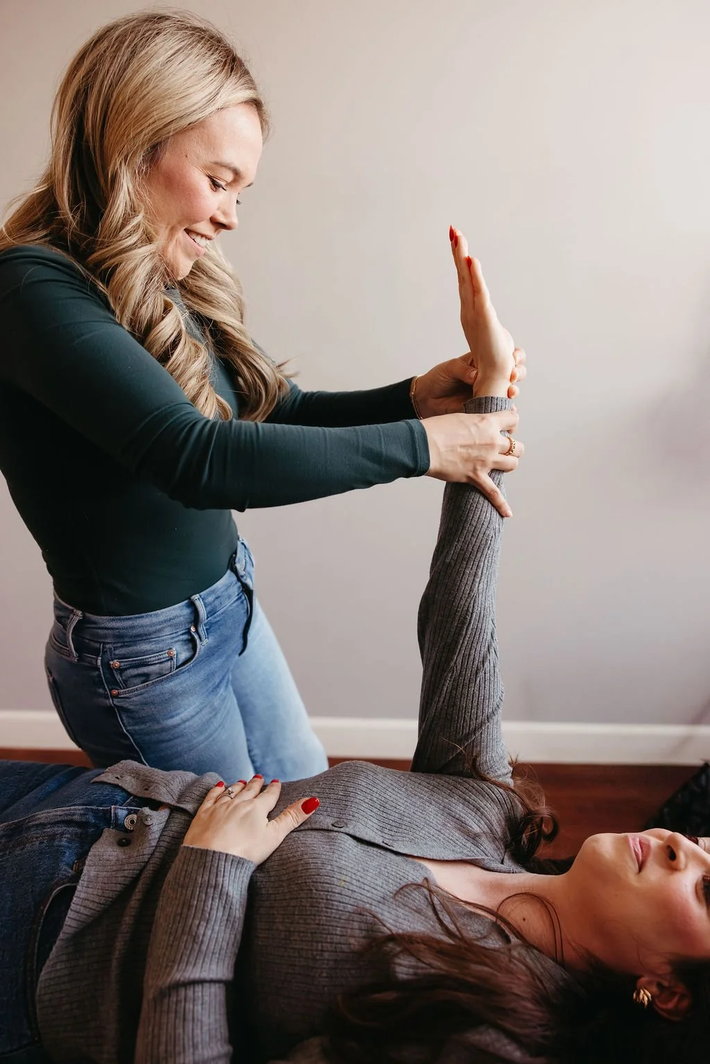 Women using muscle testing to do nervous system based chiropractic adjustment.