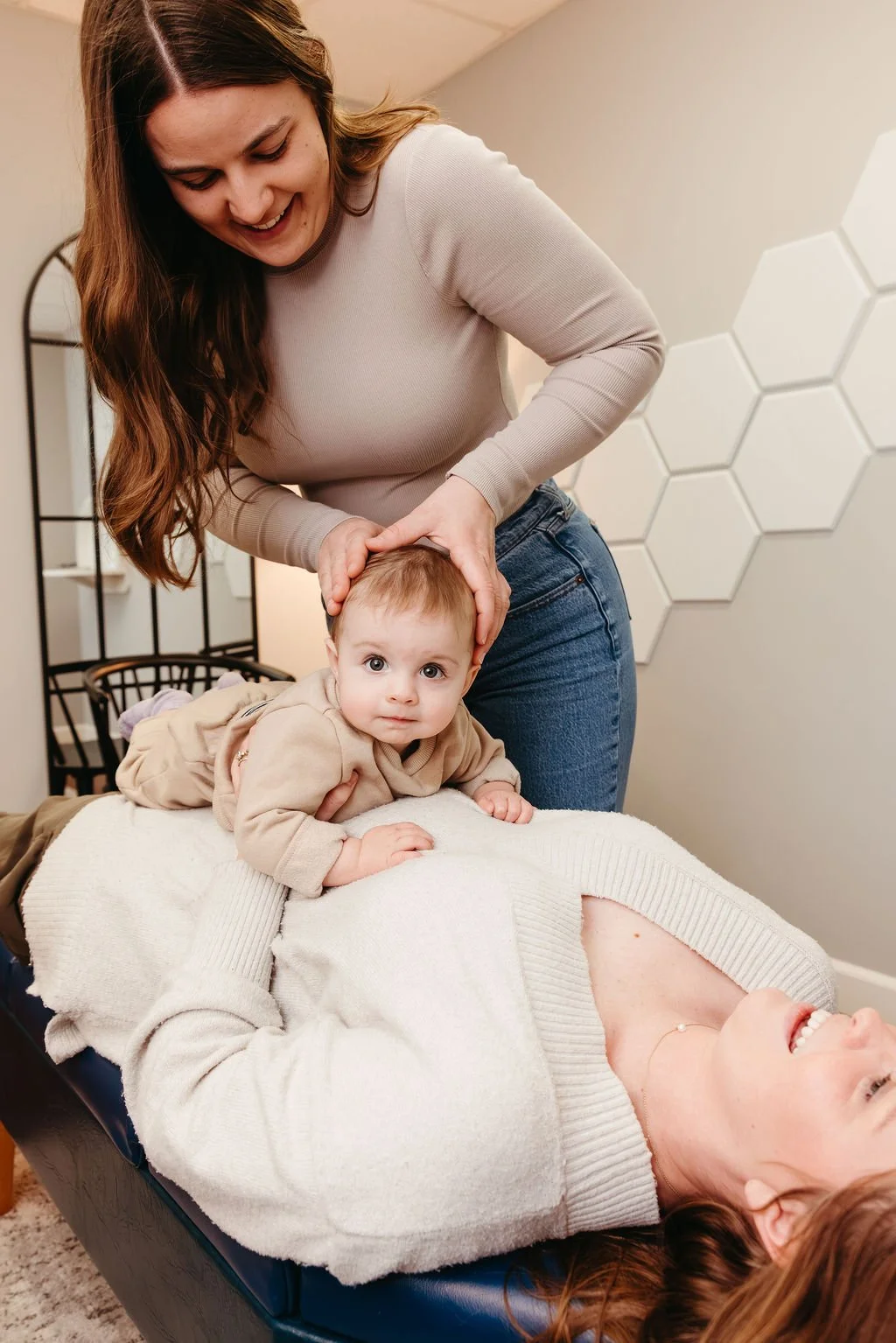 Women adjusting a toddler for latch issues, colic and sleep issues at top Nashville chiropractic clinic.