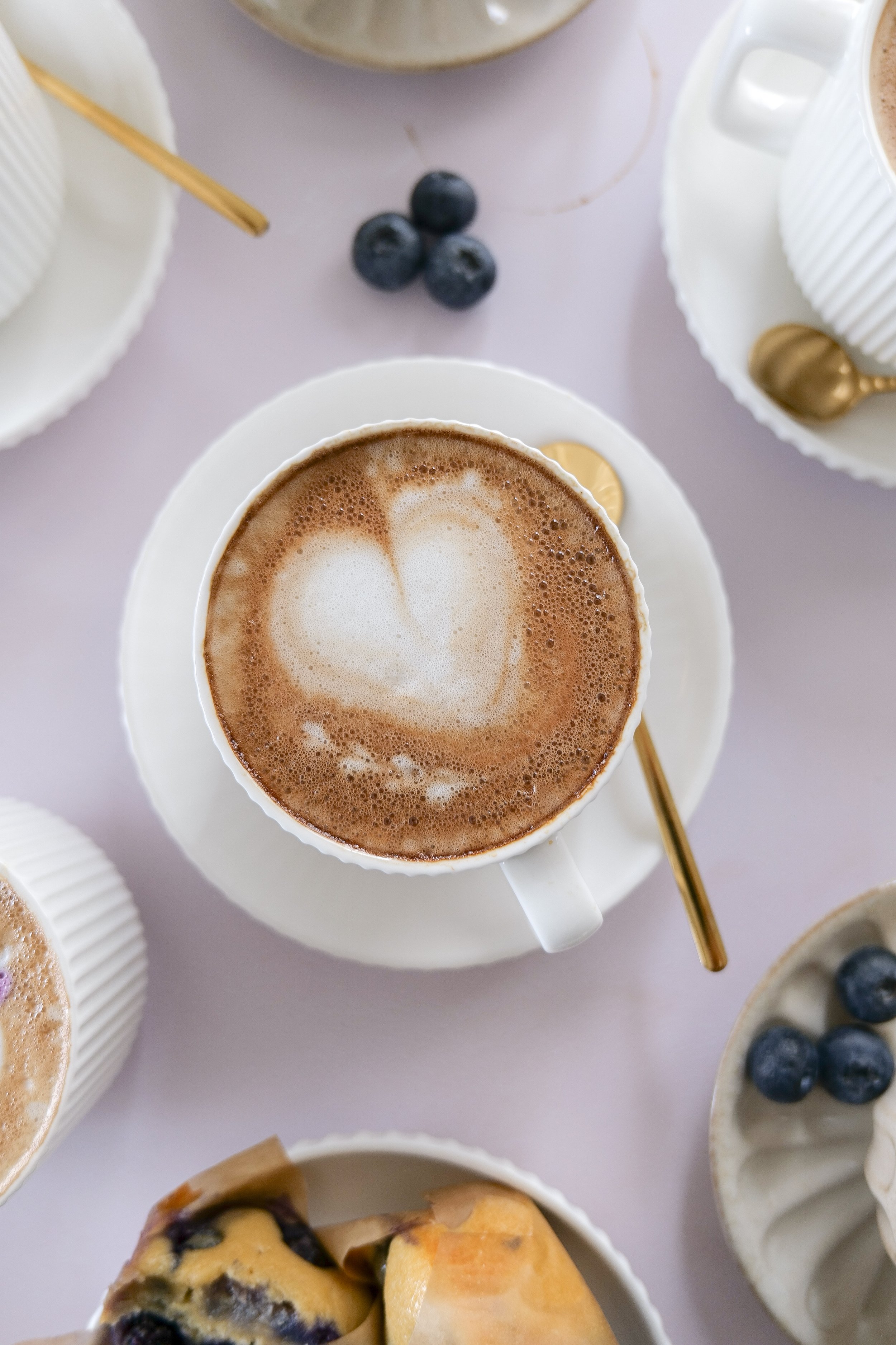 Fresh espresso being poured over homemade blueberry syrup to create a Blueberry Muffin Latte