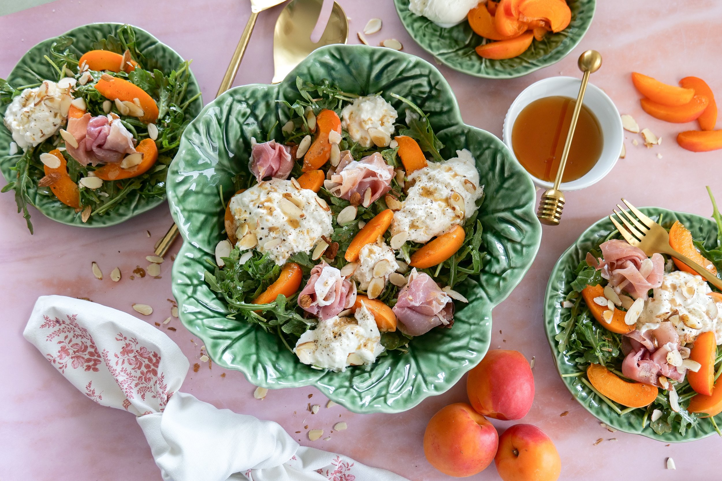 Fresh arugula salad with apricots, burrata, and sliced almonds.
