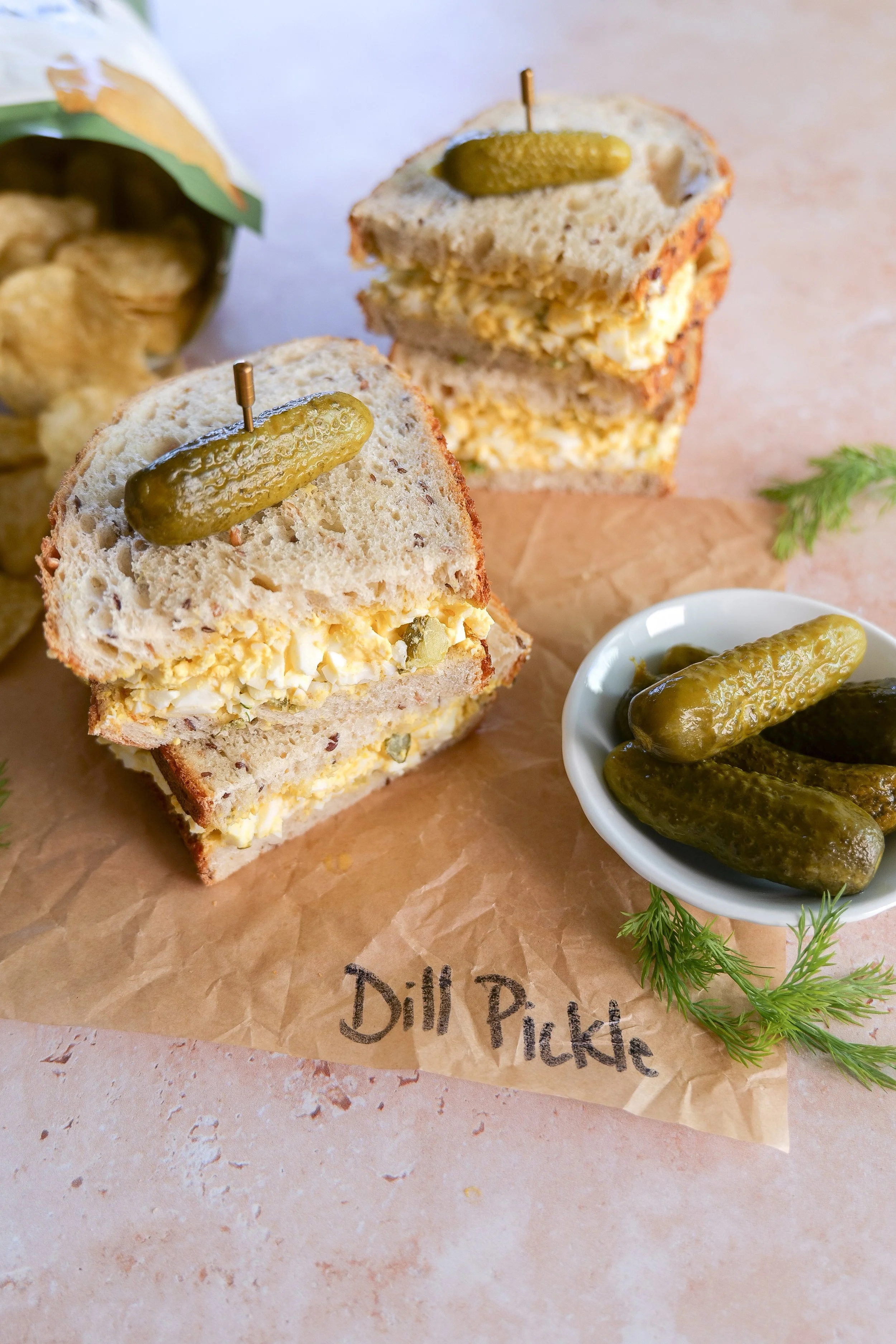 Easy egg salad sandwich with dill pickles served on fresh bread.