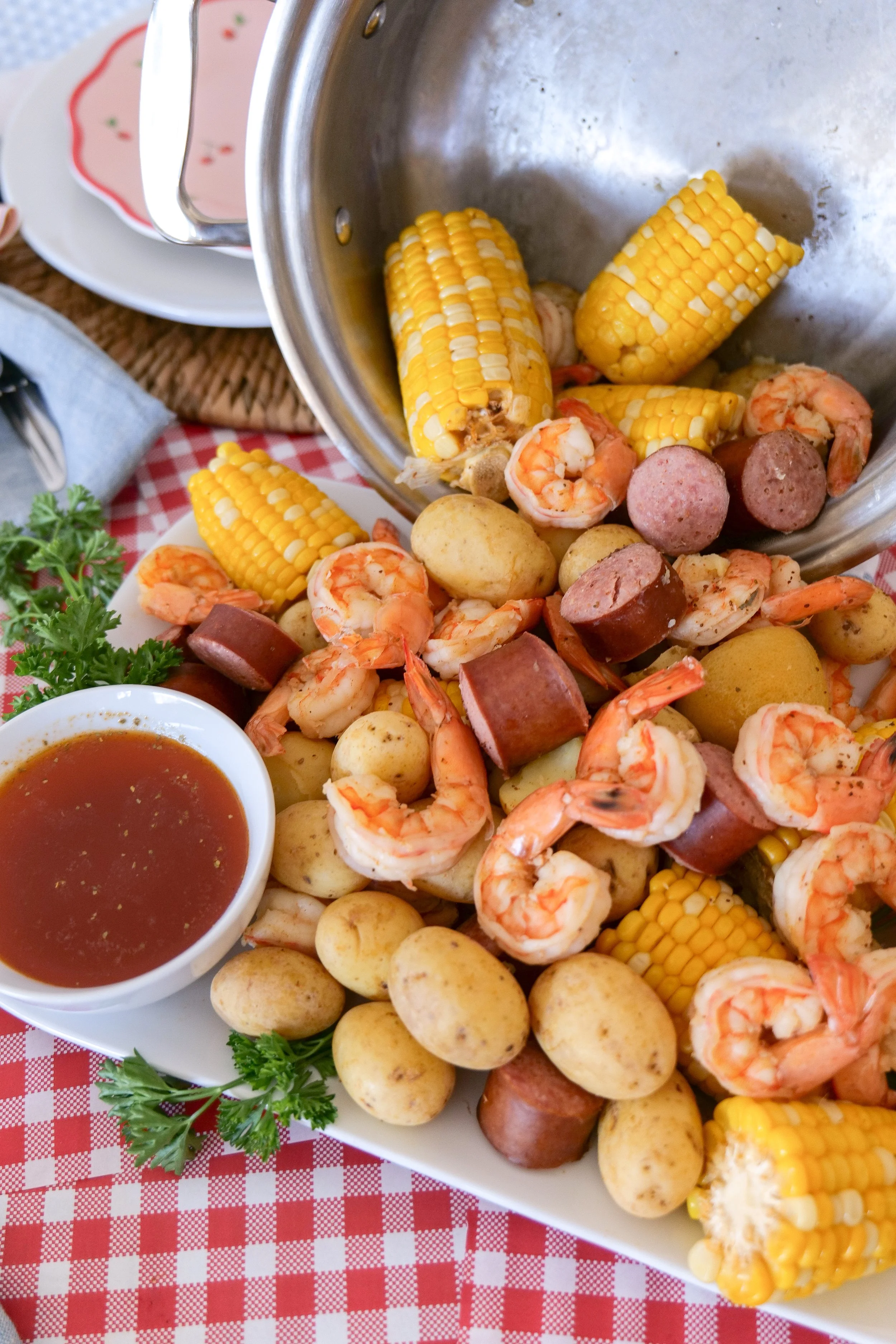 Shrimp boil displayed on a beautiful patriotic tablescape with coastal-inspired decor.