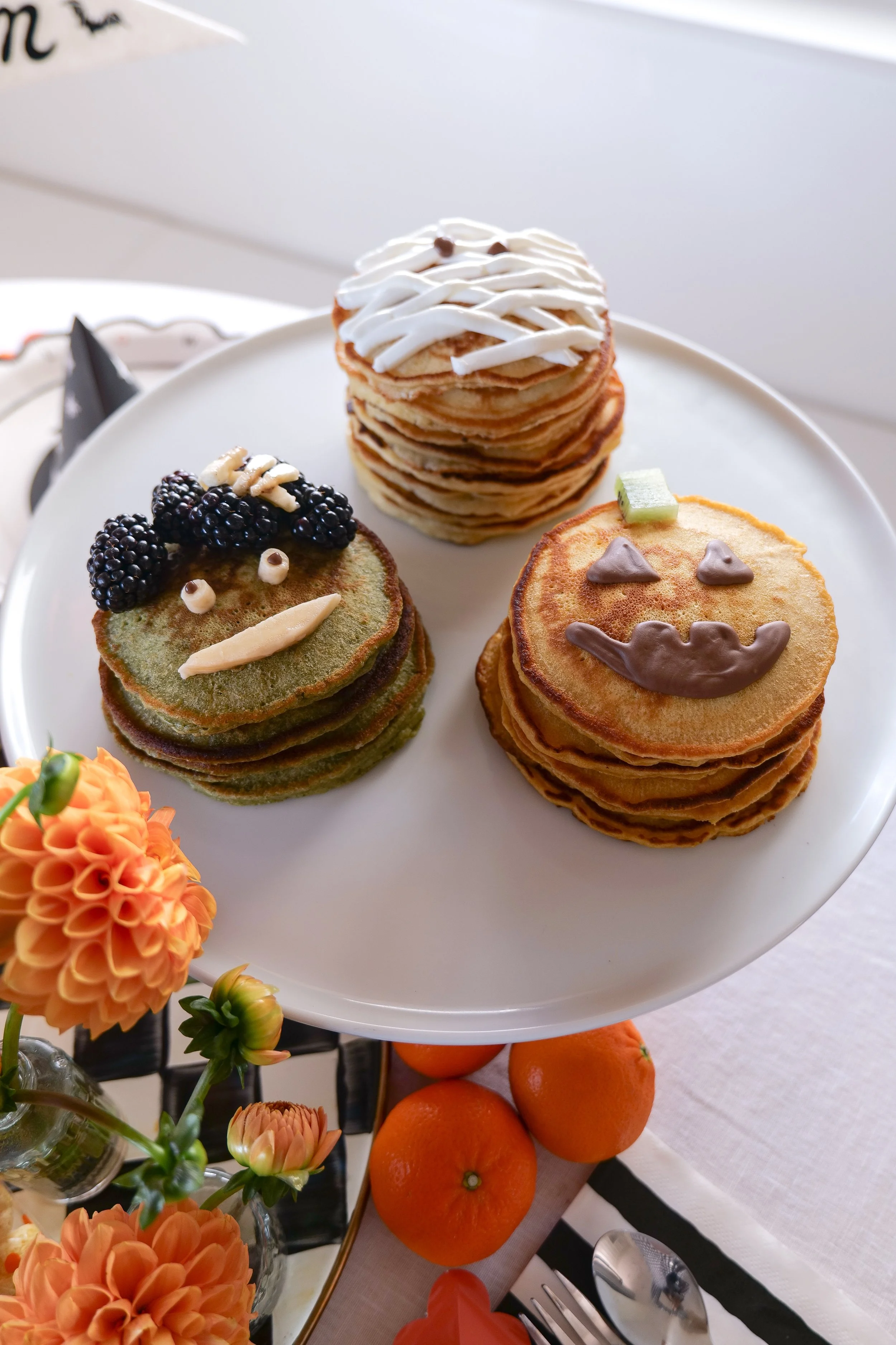 Halloween breakfast pancakes for kids decorated as a mummy, jack-o-lantern and Frankenstein.