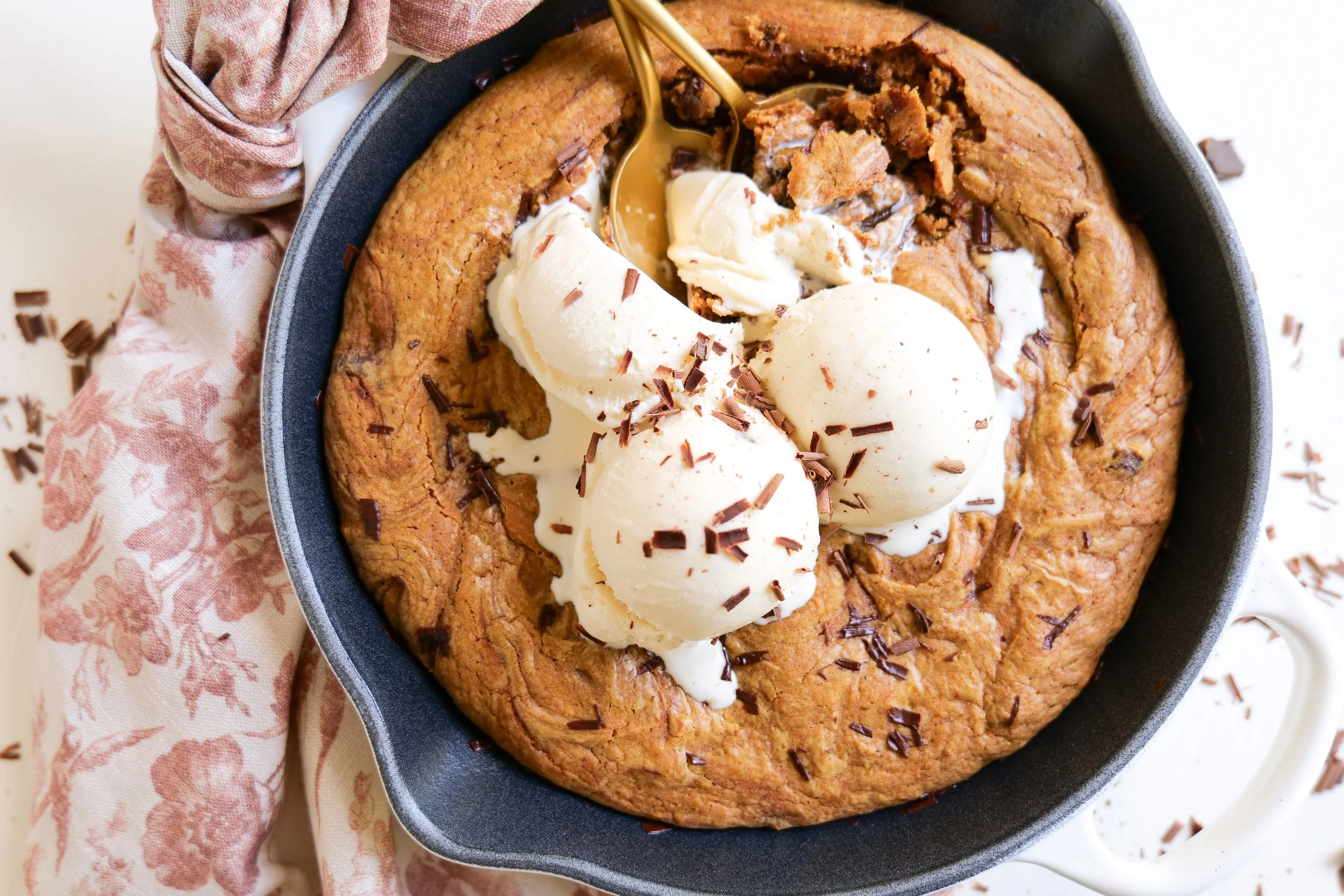 Brown butter pumpkin oatmeal skillet cookie with melted chocolate and vanilla ice cream