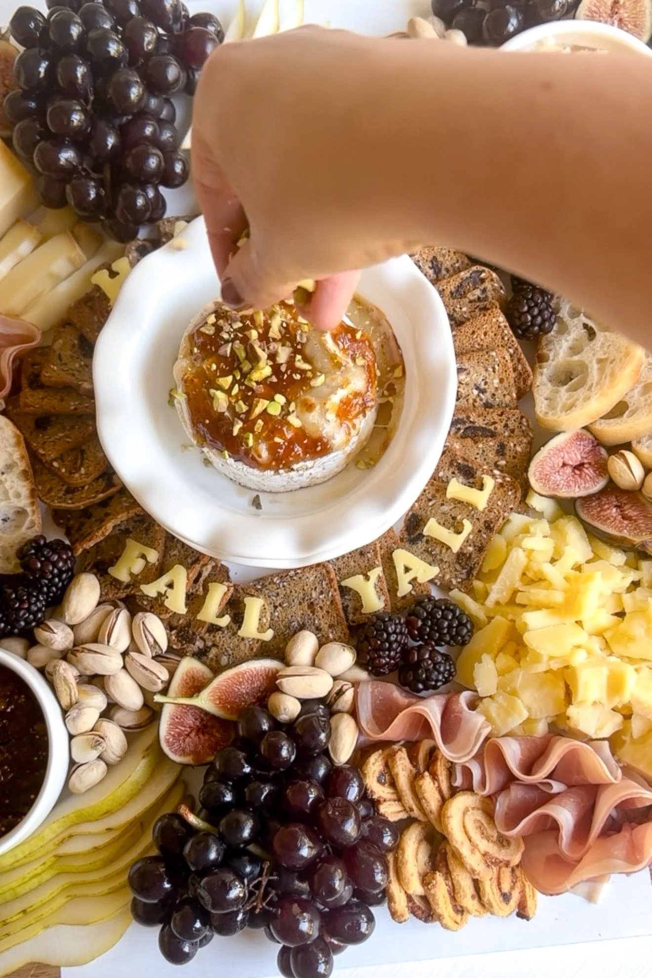 Baked Brie topped with fig jam and crushed pistachios