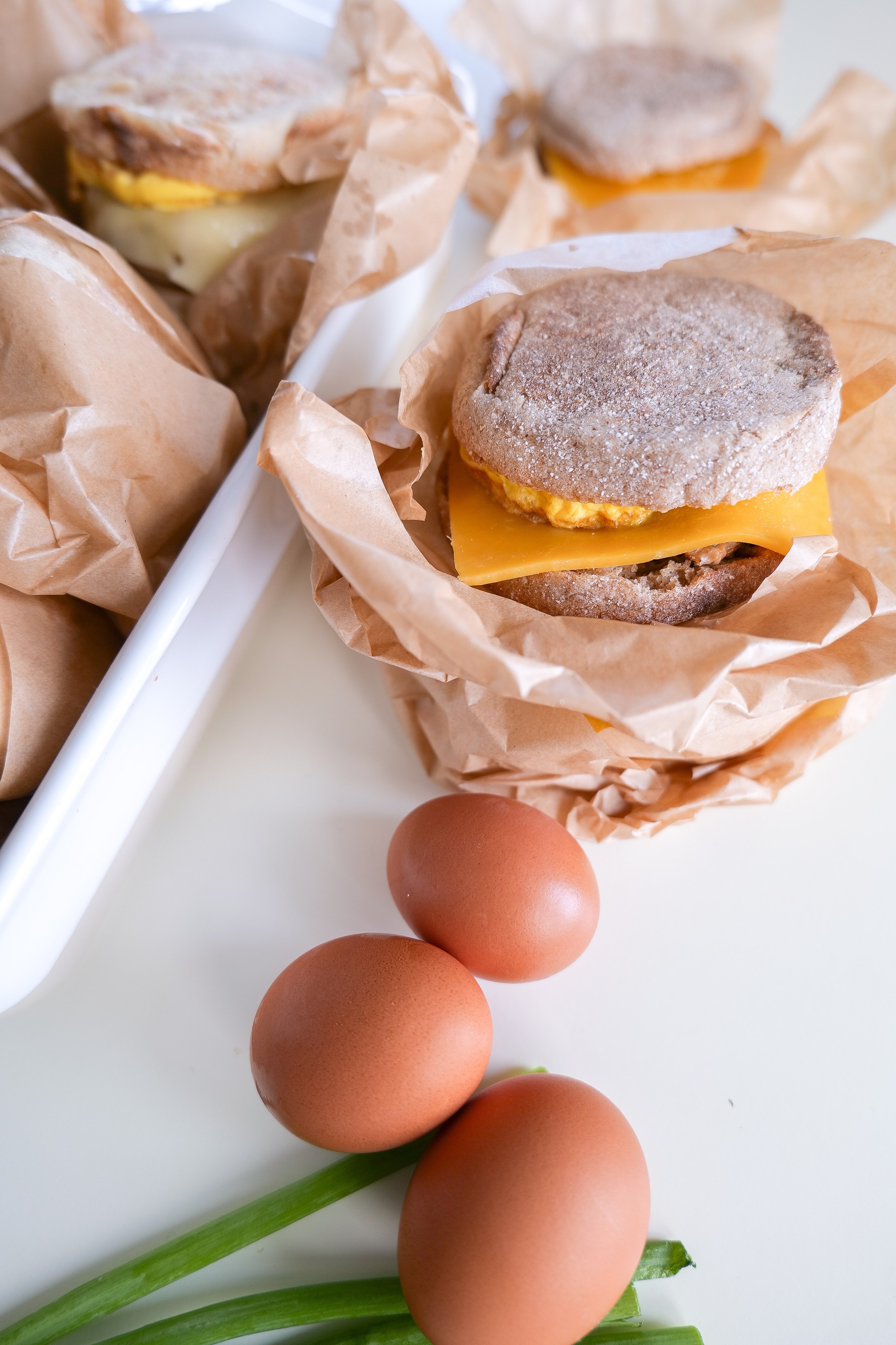 English muffin breakfast sandwich prepared with sausage, egg and cheese for meal prep.