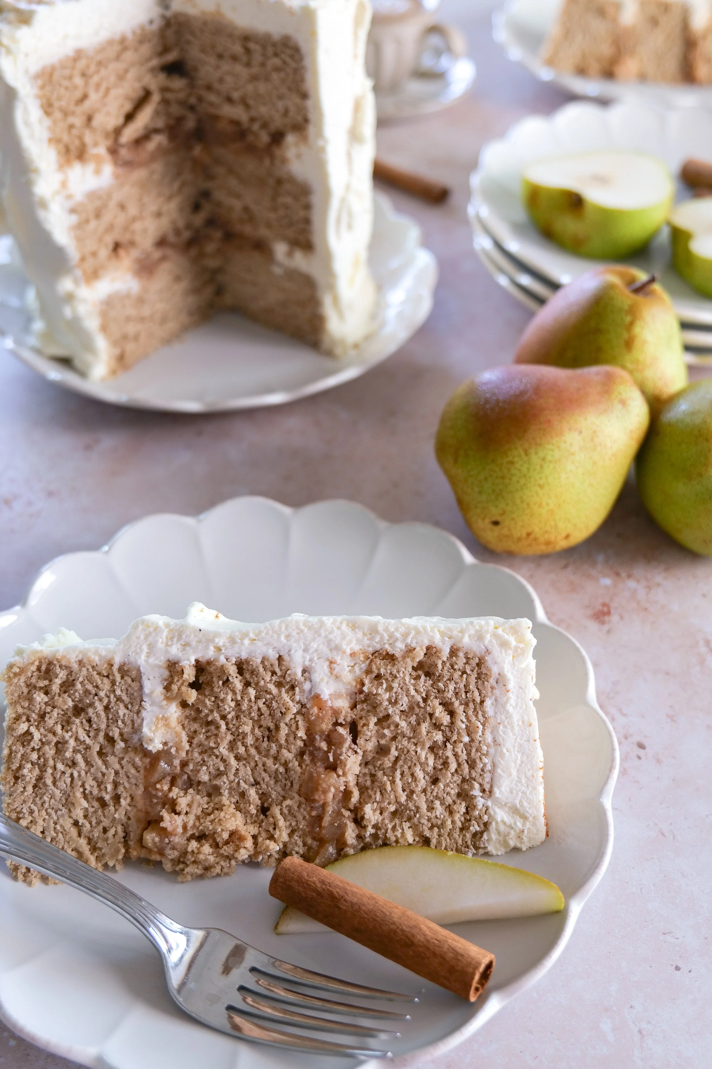 Fresh pear slices arranged on top of a mascarpone frosted cake.