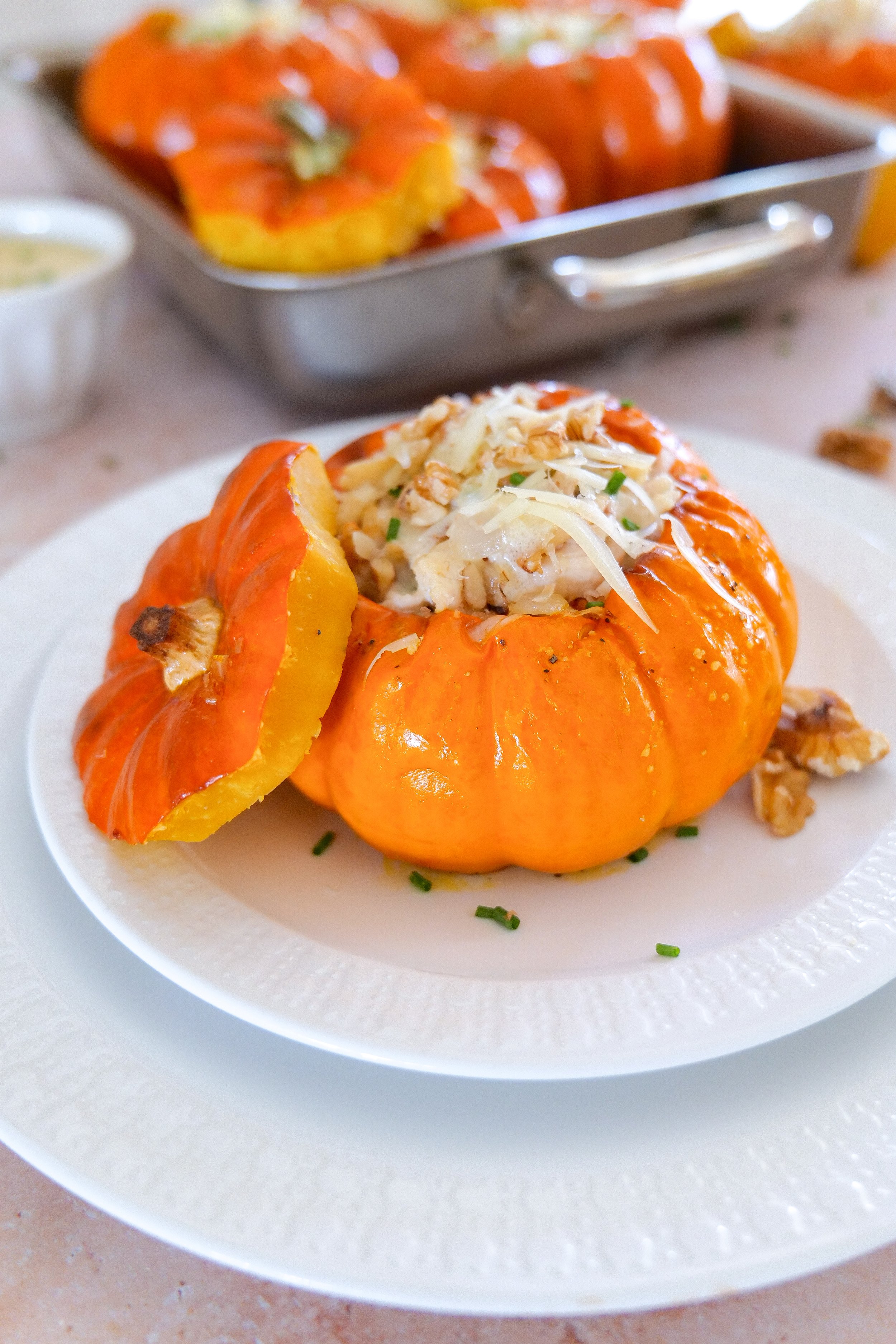 Creamy walnut chicken stuffed pumpkins with Gruyère and white wine cream sauce for a cozy fall dinner.