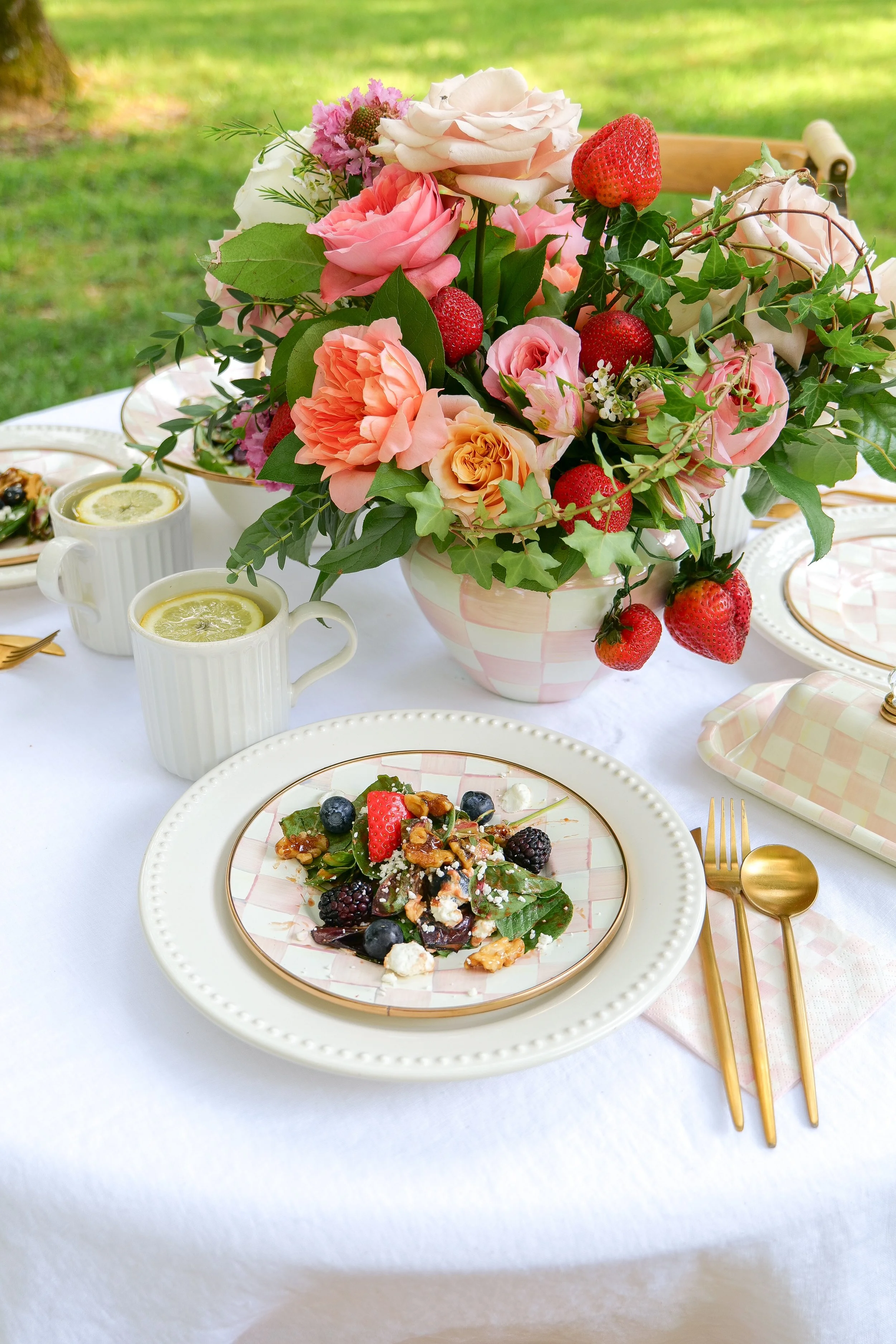 Summer outdoor table setting surrounded by lush greenery for an elegant garden lunch.