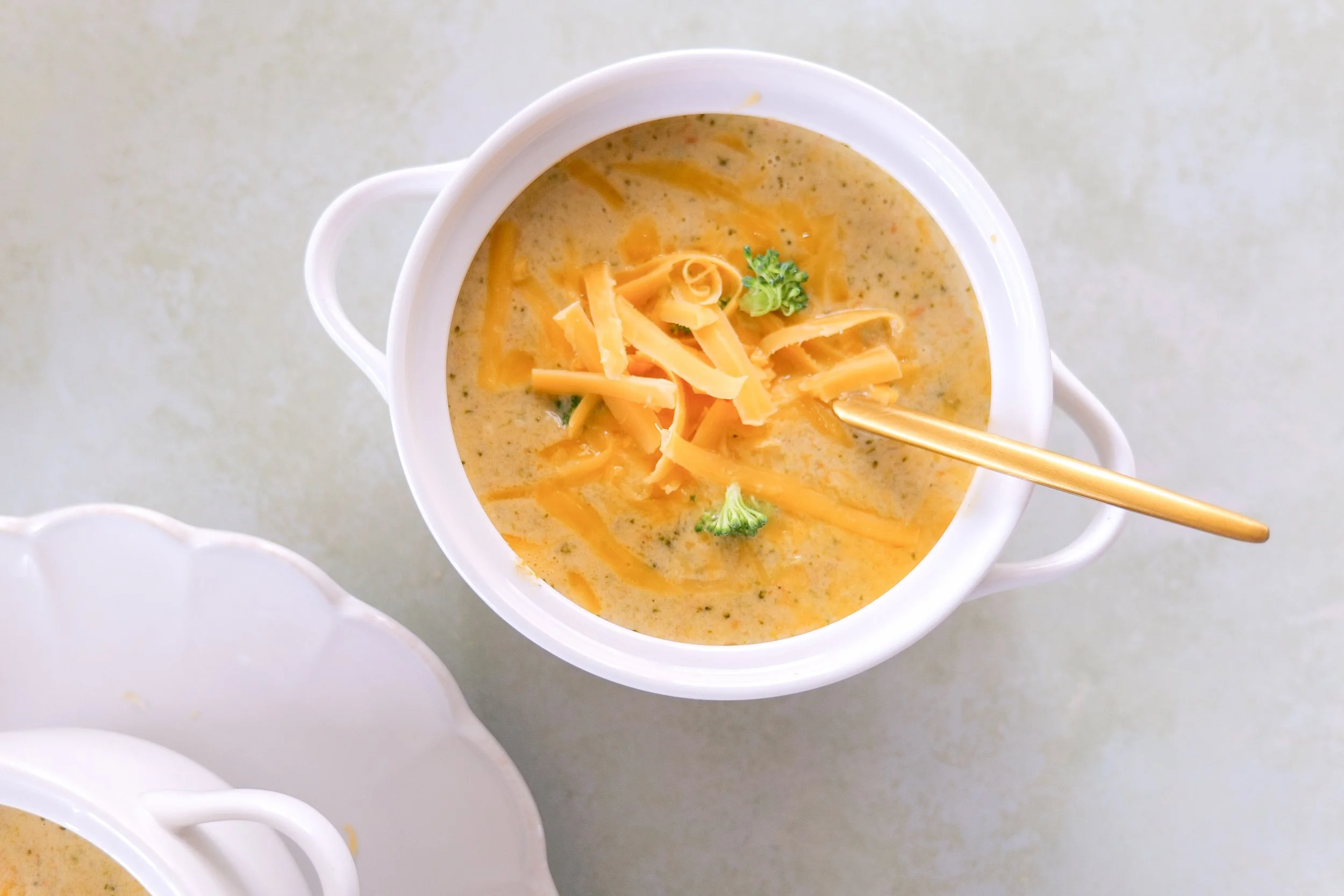 Homemade broccoli cheddar soup served warm with tender broccoli and carrots.