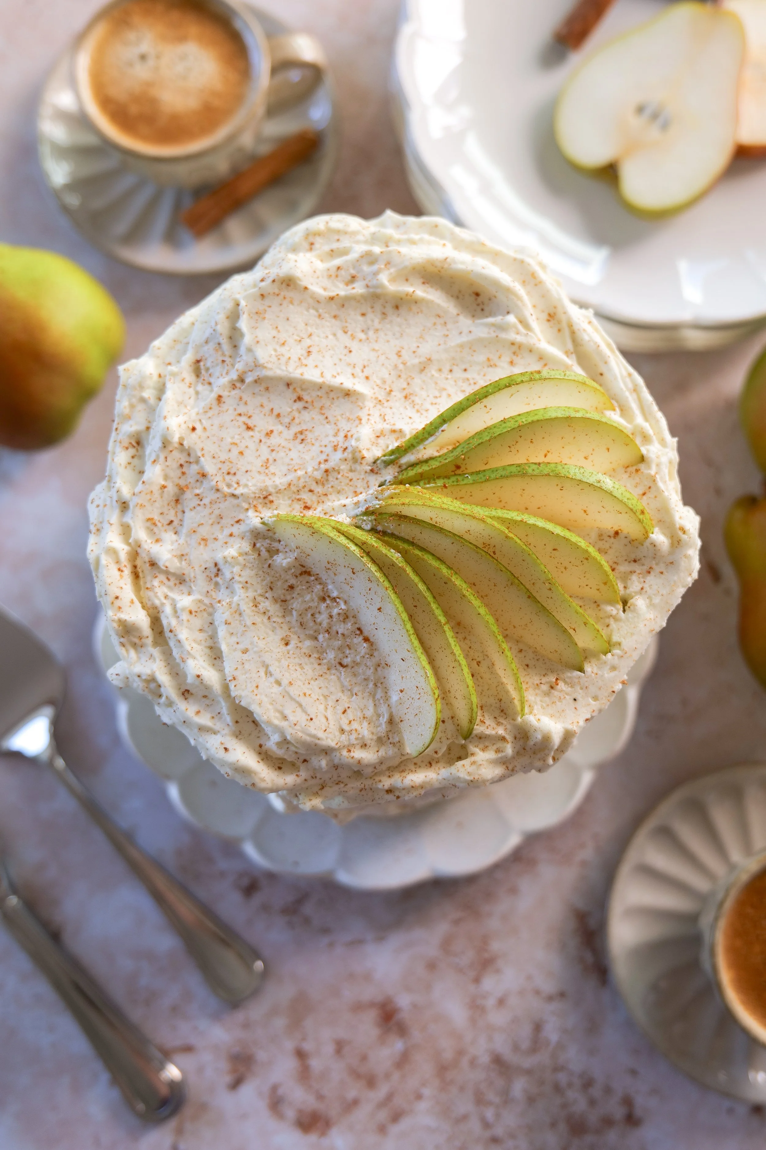 Fall pear cake with whipped mascarpone cream and fresh pear slices viewed from above.