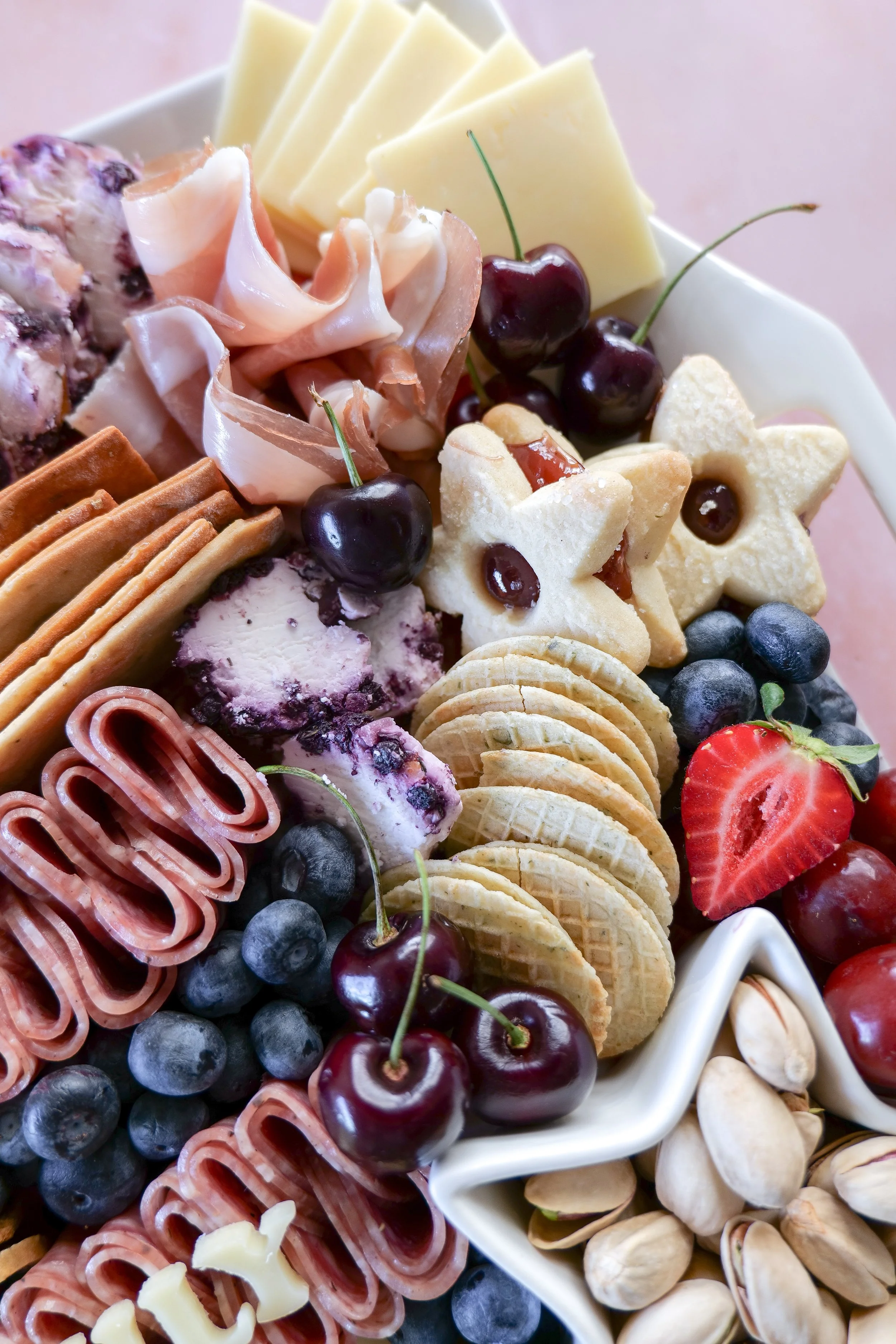 Charcuterie board featuring fresh berries and patriotic summer ingredients.