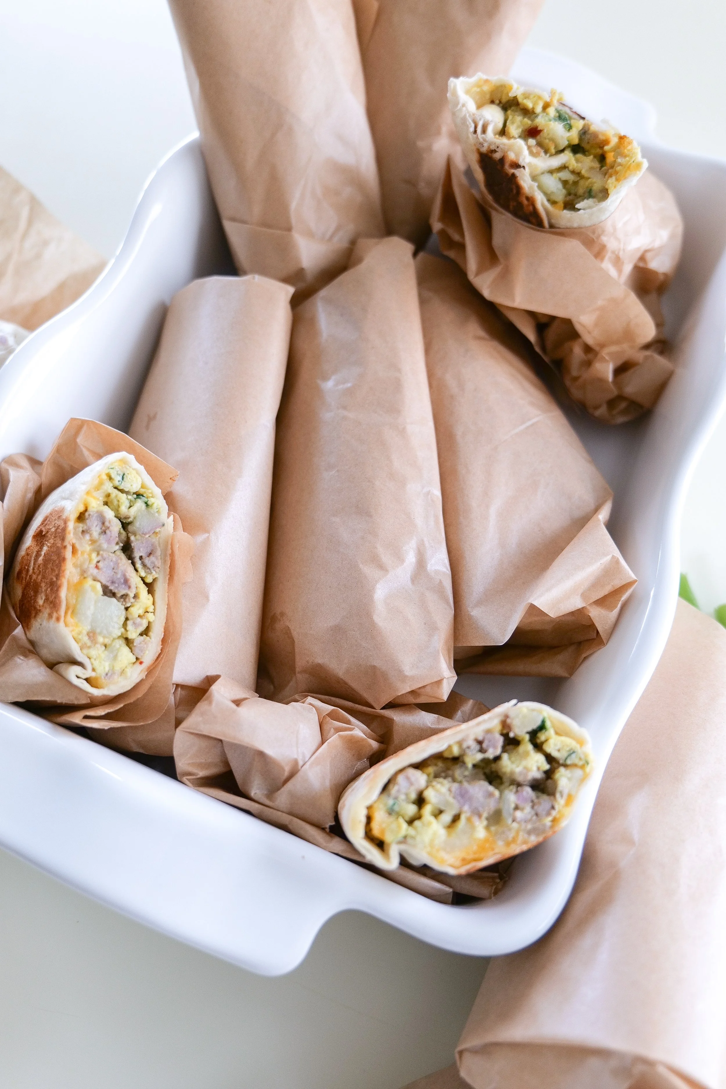 Easy make-ahead breakfast burritos wrapped individually in parchment paper for storing in the refrigerator or freezer.