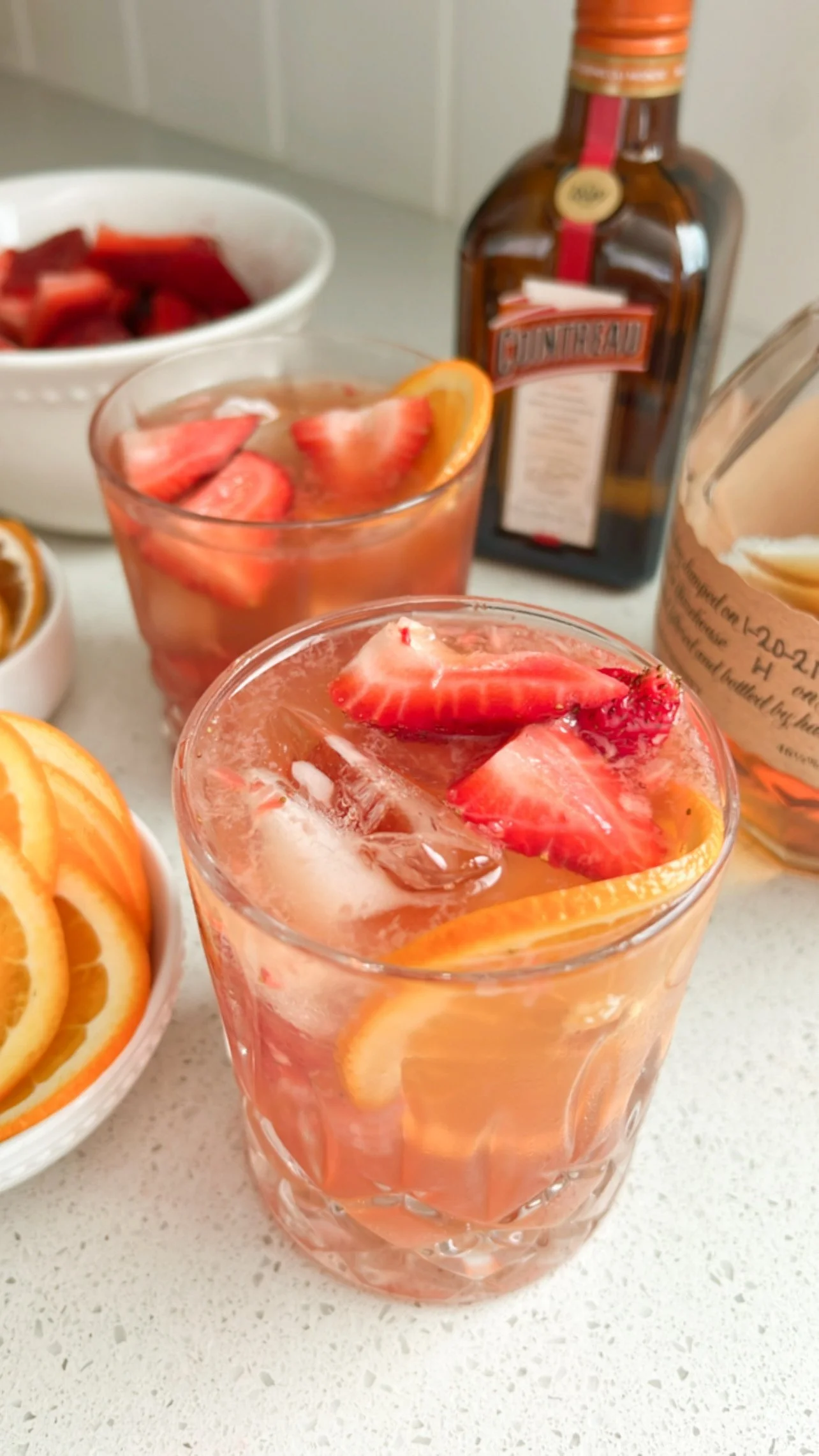 Bourbon cocktail with strawberries and fresh orange slices