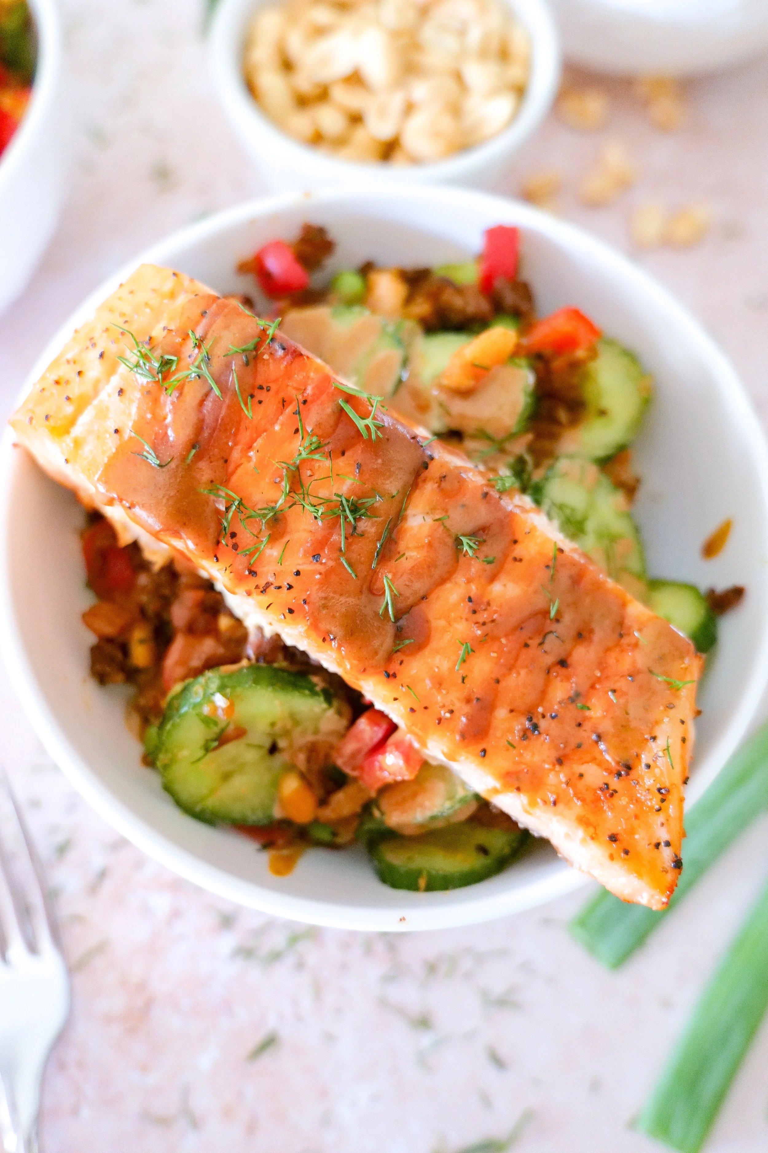 Crispy rice and salmon with colorful vegetables and homemade peanut sauce.