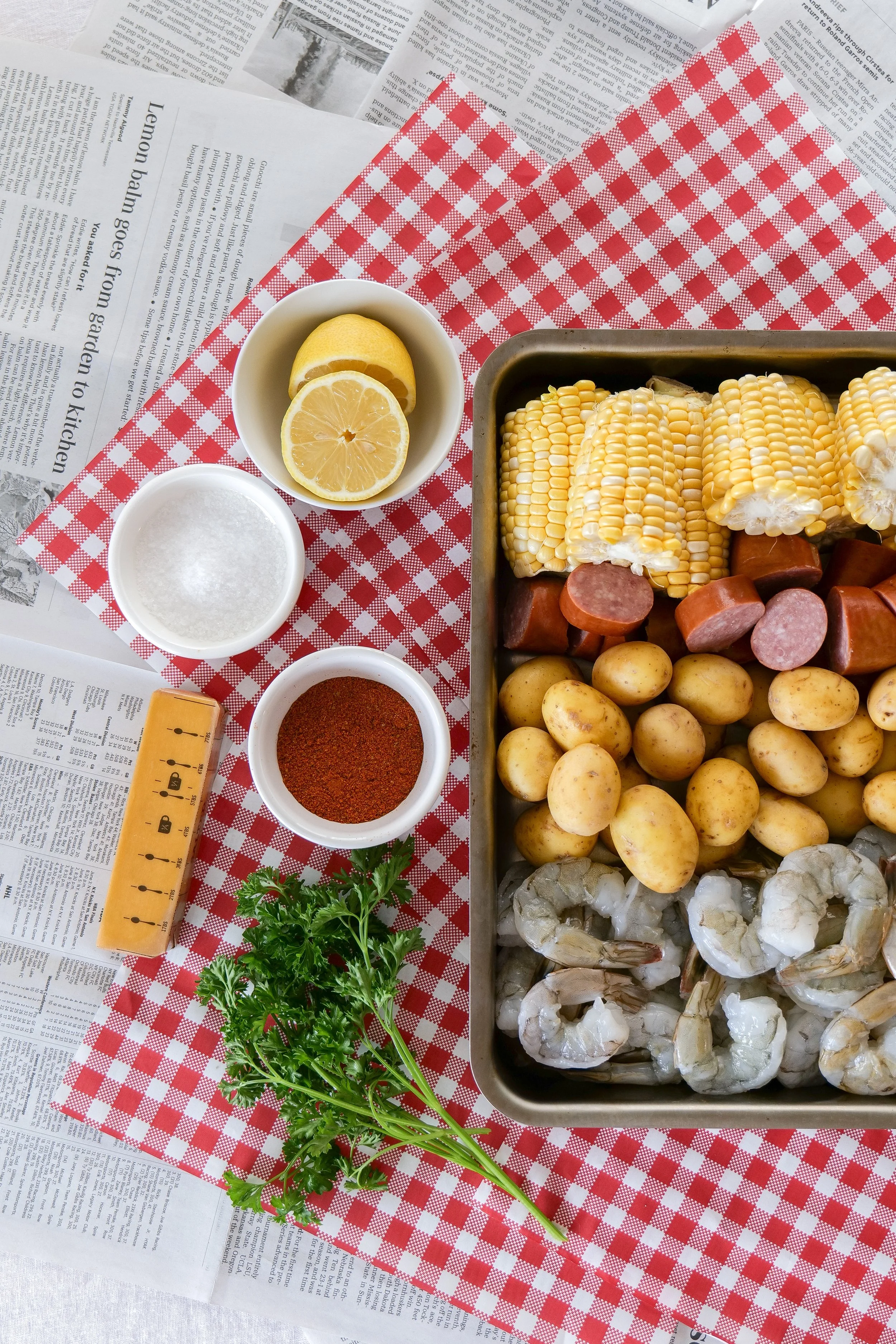 Close-up of juicy shrimp, buttery corn, and smoked sausage in a classic shrimp boil.